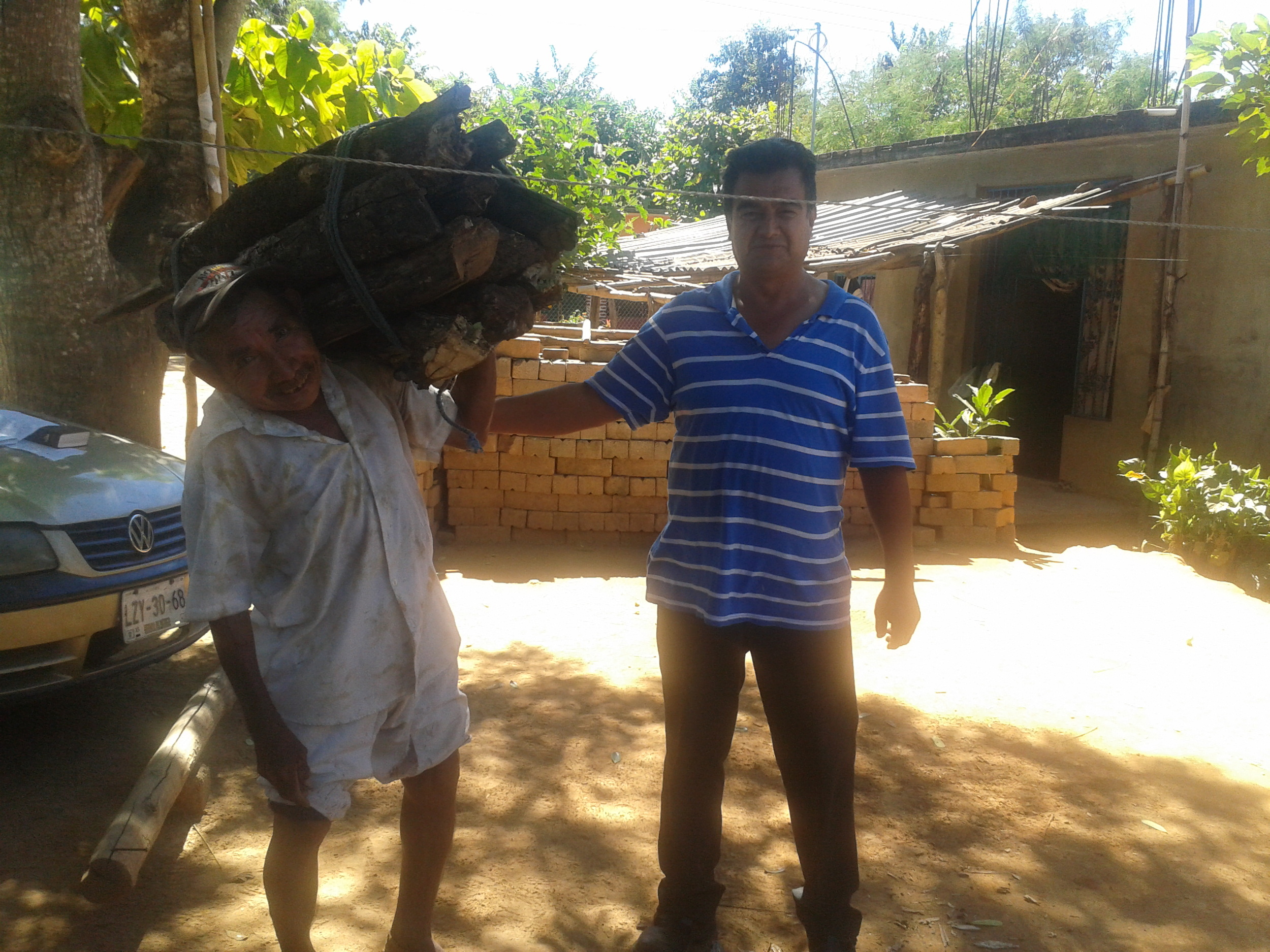 The pastor, in traditional Mixtec breeches and shirt, with Norberto, carrying firewood for cooking fires 