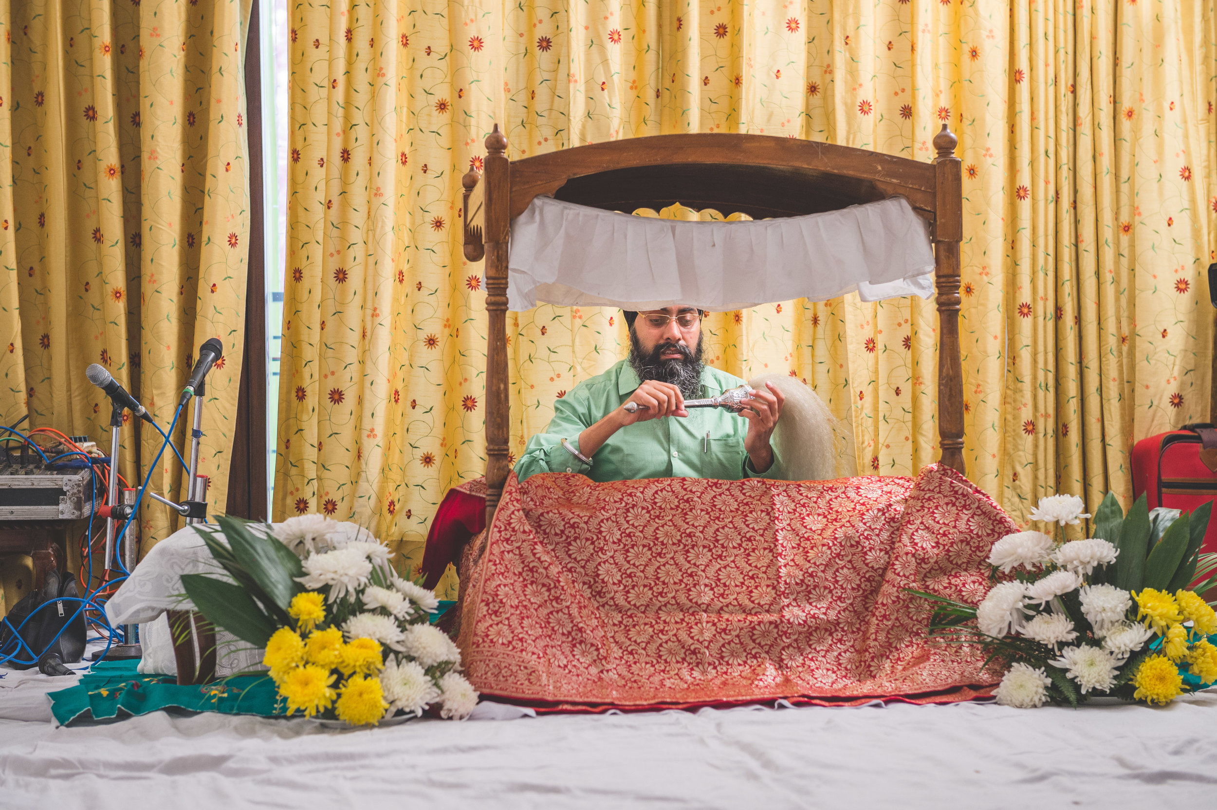  Notice the white clean sheets on the floor together with the fresh flowers placed beside the Guru Granth Sahib. 