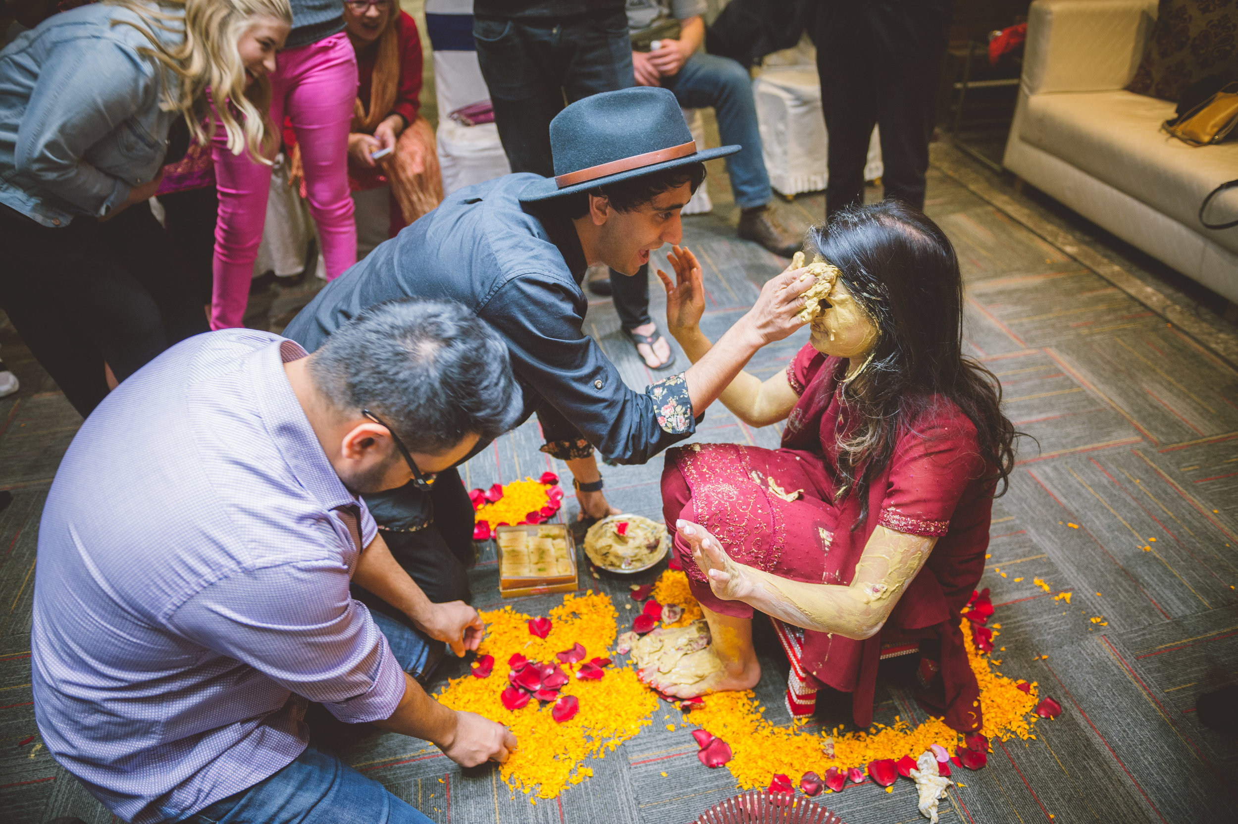  The bride's youngest brother putting a good amount of turmeric paste on his sister's face. 