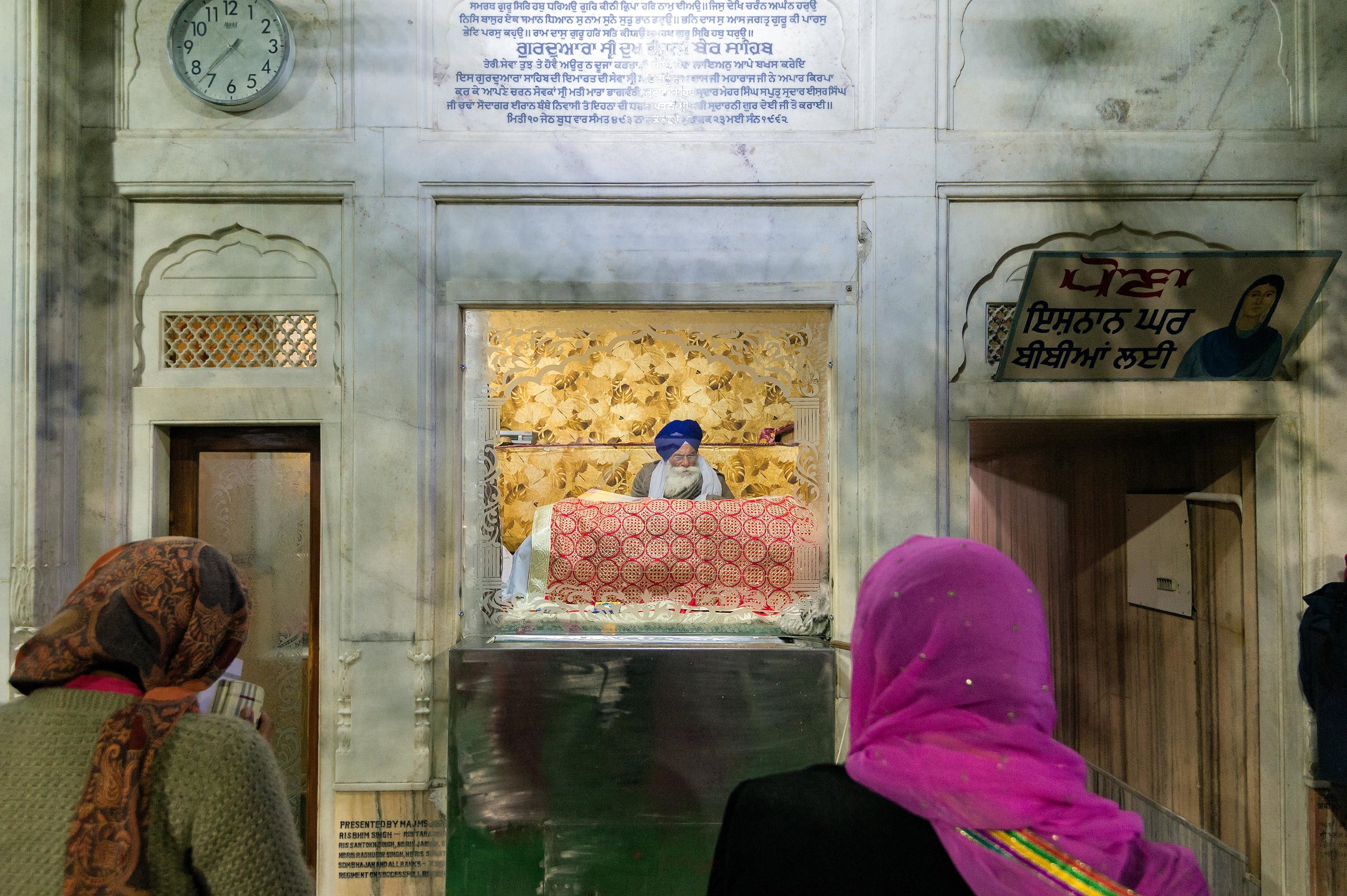  Here, you can see a priest reading text from the Holy Book (Guru Granth Sahib). 