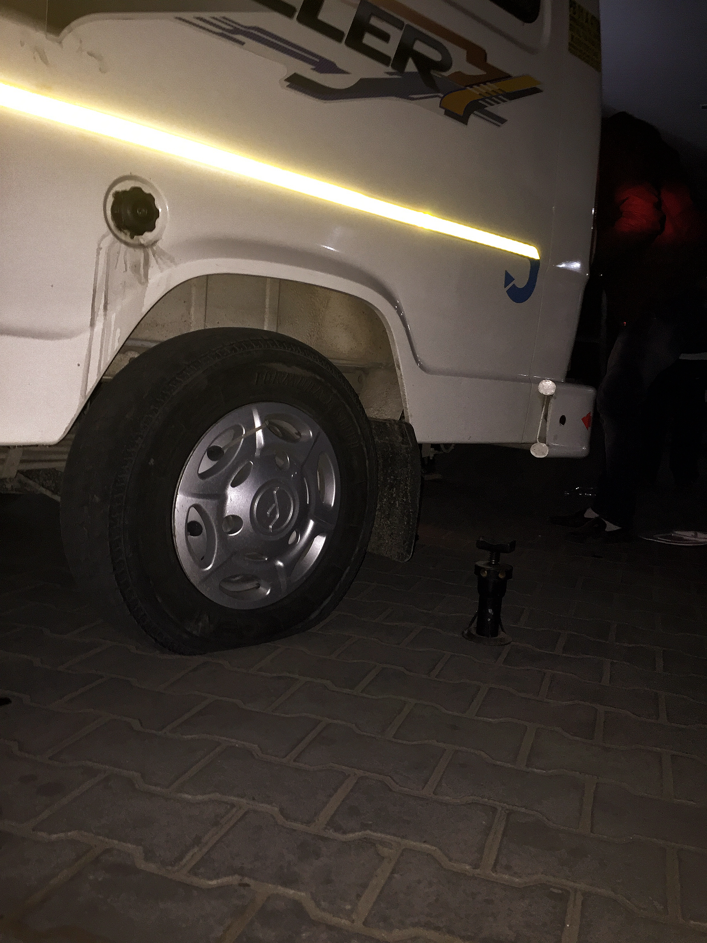  It took the driver about 40mins to change the flat tyre out. Most of us helped by shining our mobile phone lights so that he can see better.  (Image taken with iPhone 6+)  