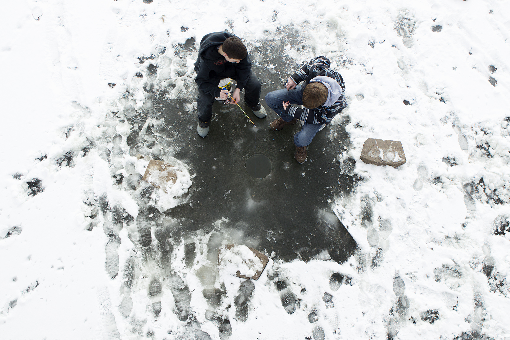 Kain Sherman, left, and Gavin Sidener fish through a hole in the ice on the Gillette Fishing Lake at Dalbey Memorial Park.
