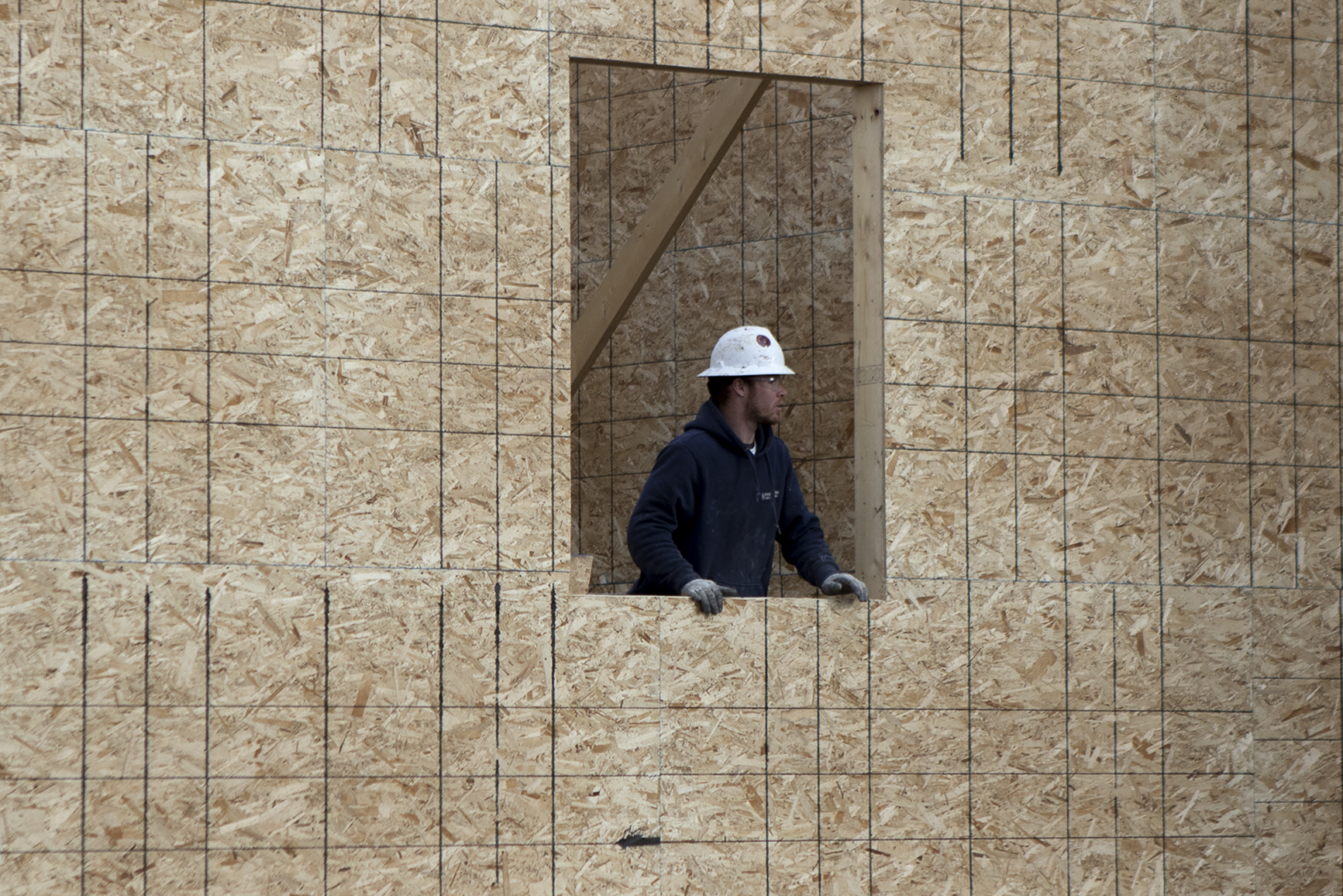 A worker with Van Ewing Constructions talks to another crew member through a window Wednesday afternoon at while working on the new dorms at Gillette College.