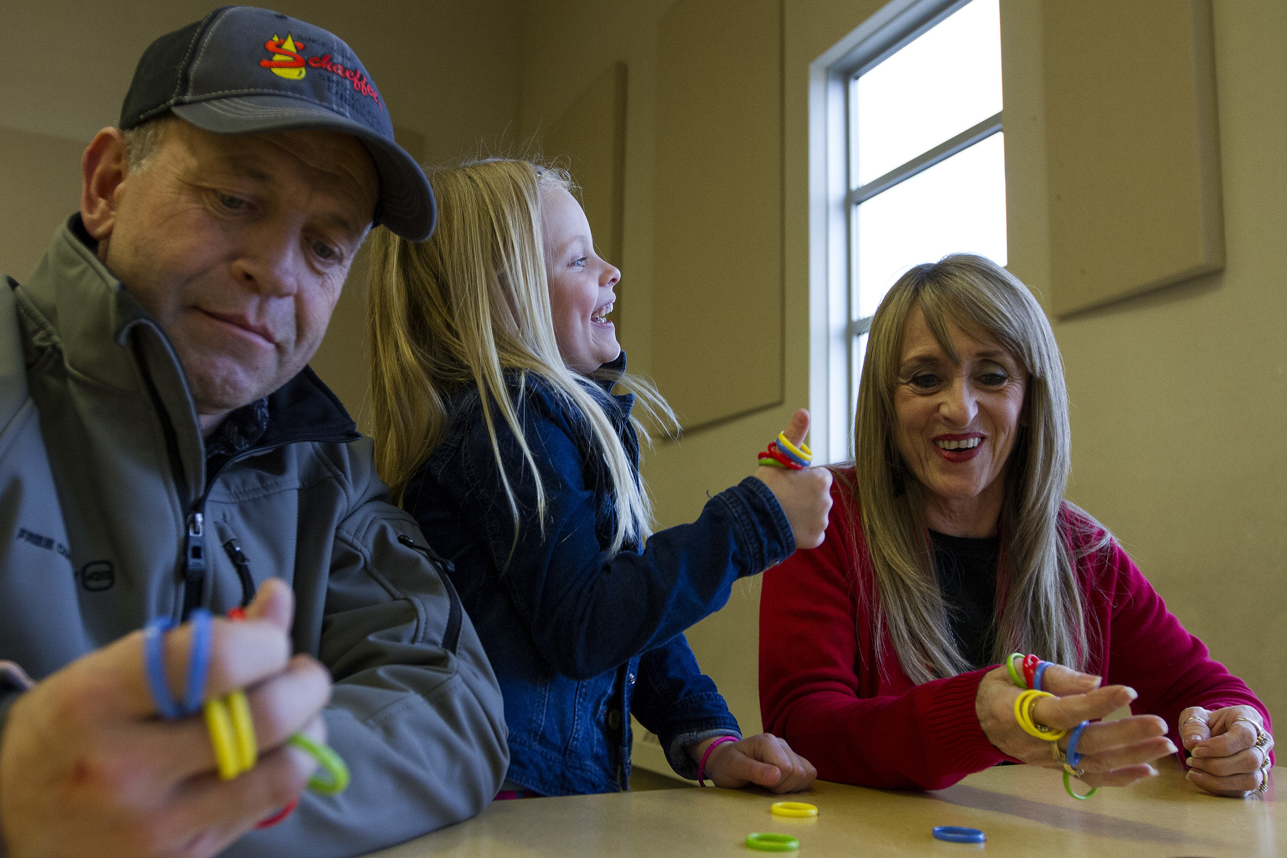 Abby Millburg, 6, a first grader at Prairie Wind Elementary laughs as she beats her grandparents Ross Rohde and Judy Rohde at a game of Thumbs Up, Monday evening in the Prairie Wind cafeteria. The event, Grandparents and Games, was started last year by the Parent Teacher Organization at Prairie Wind with help from Teacher's Corner/Kid's Mart. This year the store provided more than 10 different games for families to play, and will donate 10% of the sales of games to those families back to the school.