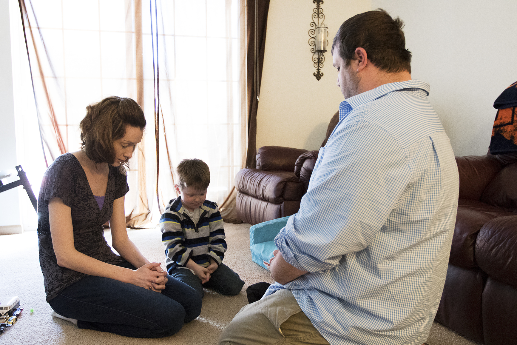 Shauna, 4-year-old Jacob and Kuillin Orcutt pray before eating lunch on Saturday April 2, 2016 at their apartment in Gillette. Kuillin, who led the family in prayer, asked for help through this tough time as he begins looking for new work after being laid off from the North Antelope Rochelle mine on Thursday.