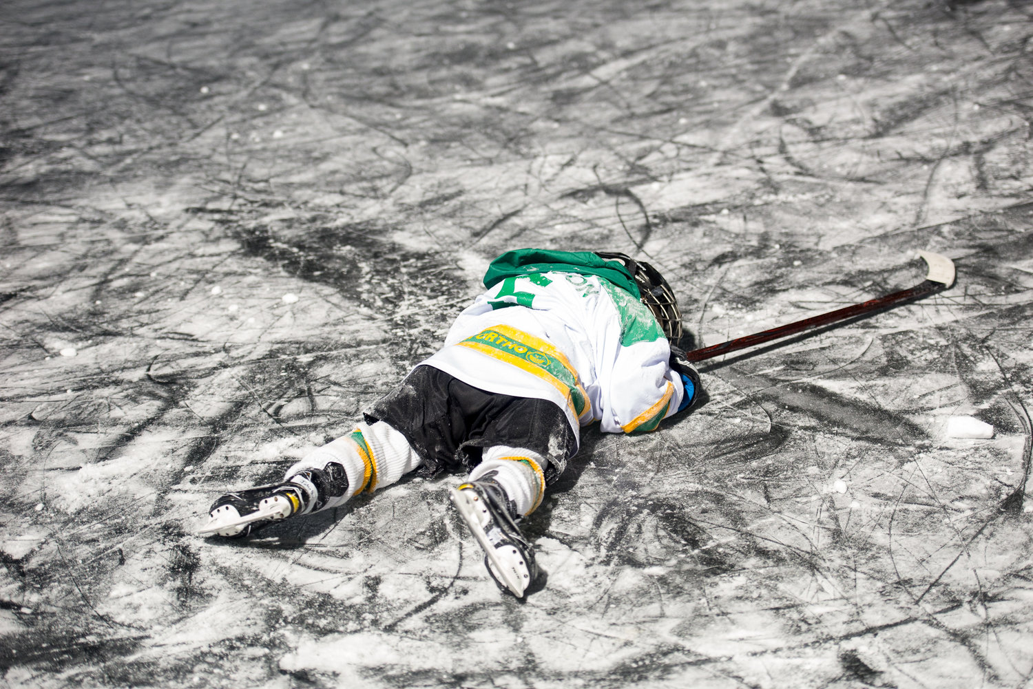 A youth hockey player lays on the ice after falling during the 2018 U.S. Pond Hockey Championships on Lake Nokomis on January 25, 2018.