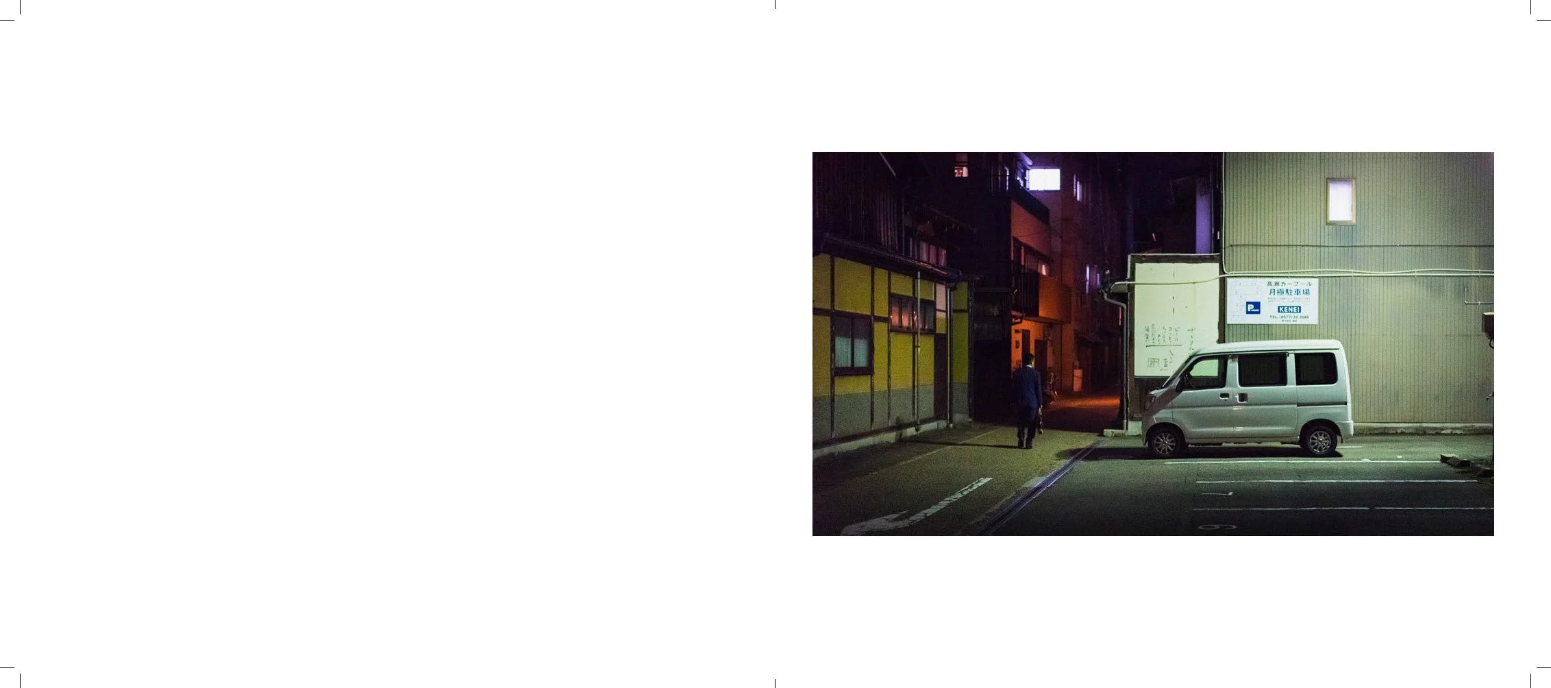 Nighttime city street scene with a white van parked next to a building, a person walking, and colorful illuminated windows.
