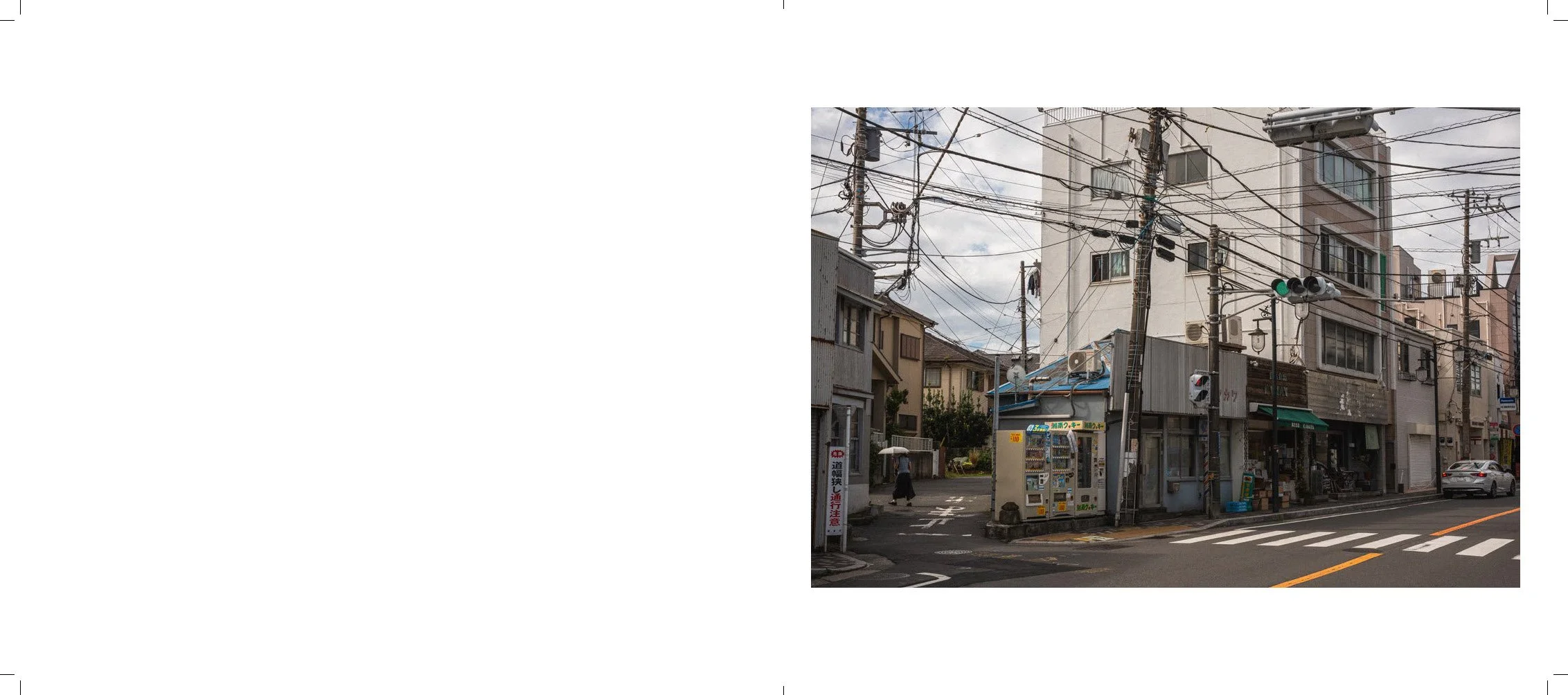 Urban street scene with utility poles and wires, buildings, and a crosswalk.