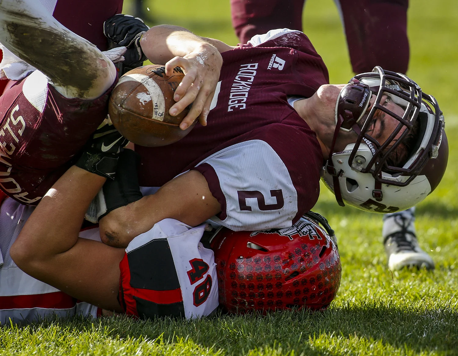 Rockridge quarterback Riley Fetterer (2) grimaces as he is brought down by Fulton's Cole McClary (48) after running a quarterback keeper during the second quarter of their game at Rockridge High School in Edgington, Illinois, on Saturday, November 5, 2016. Fulton defeated Rockridge 28-20 in the second round playoff game. 