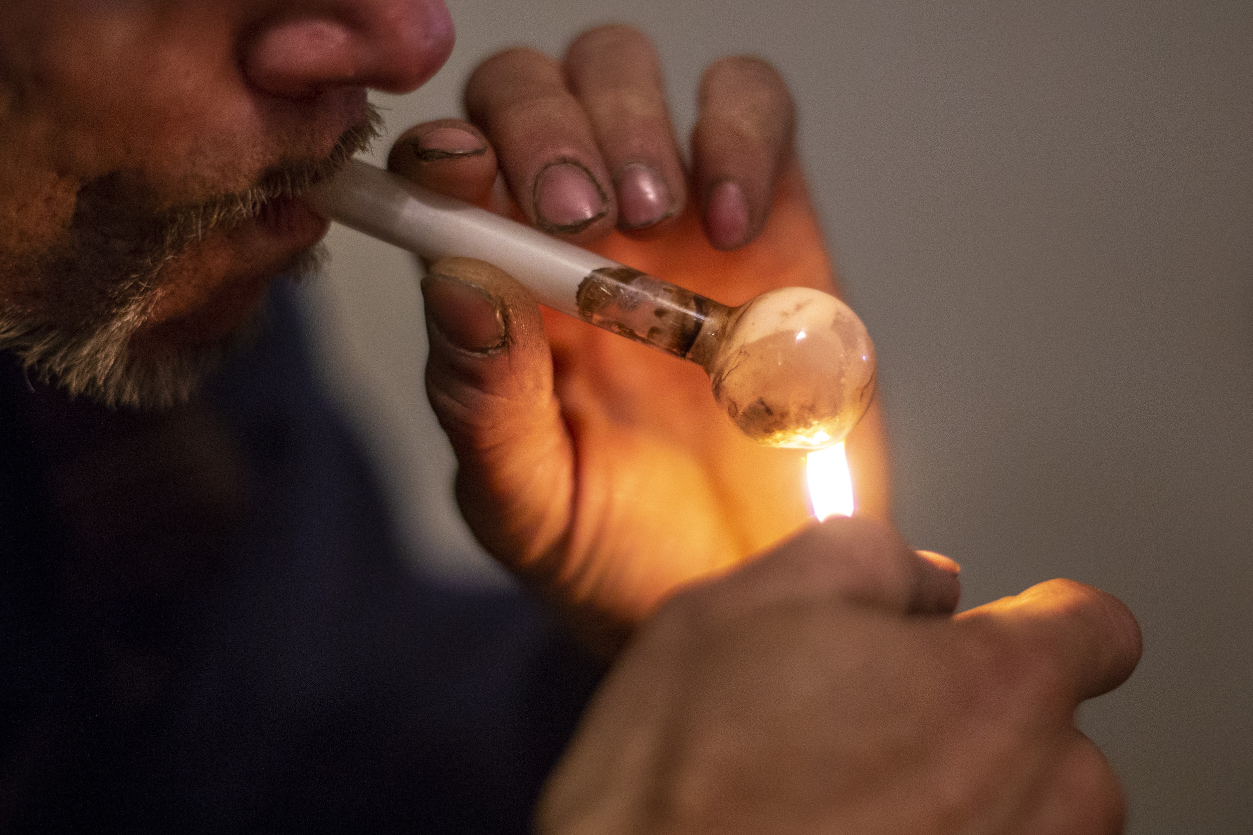 "T", 38, a methamphetamine user of 15 years, holds his lighter to...