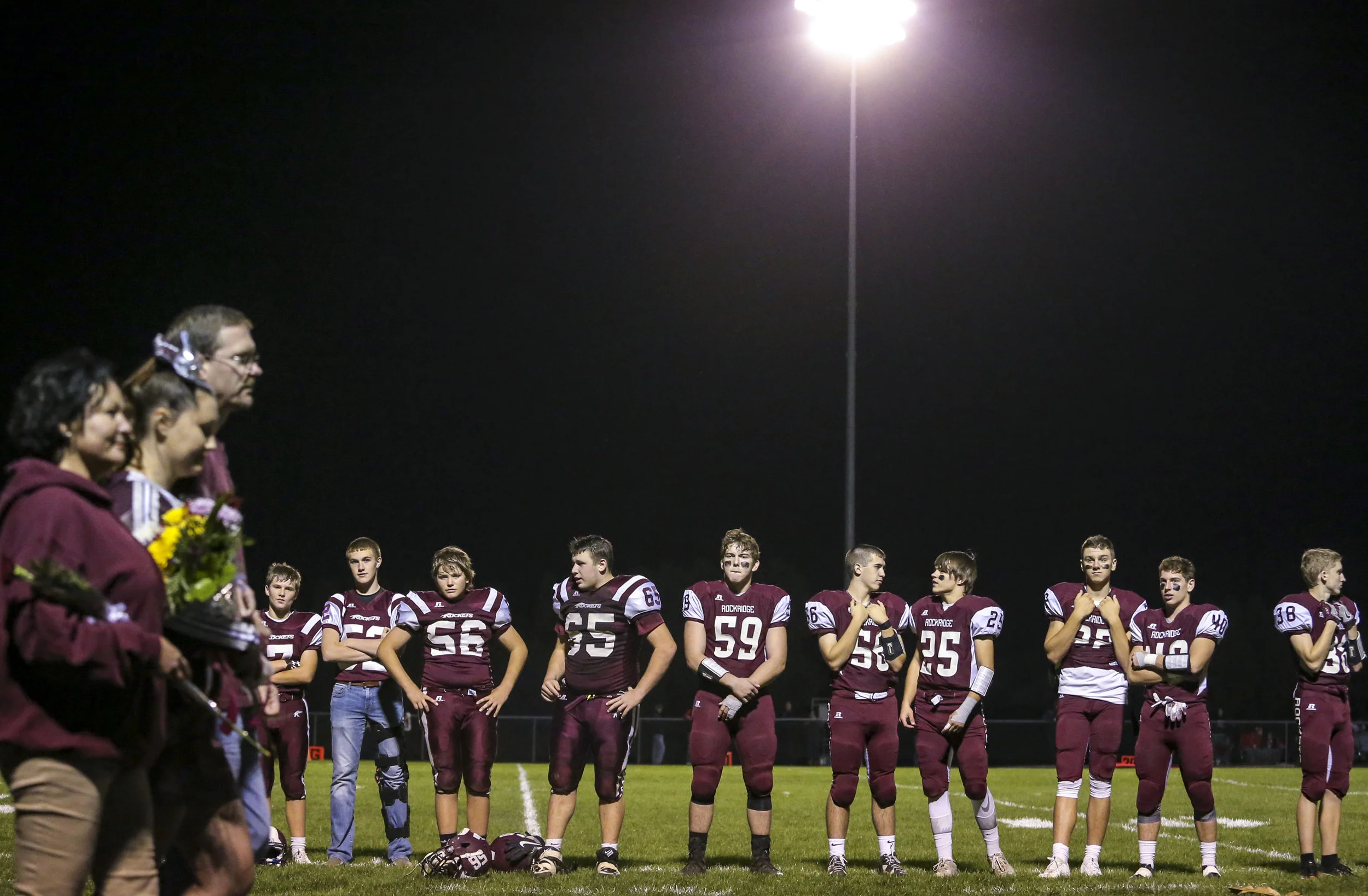 Rockridge players stand and watch senior night celebrations take place before their game at Rockridge High School in Edginton, Friday, October 20, 2017.