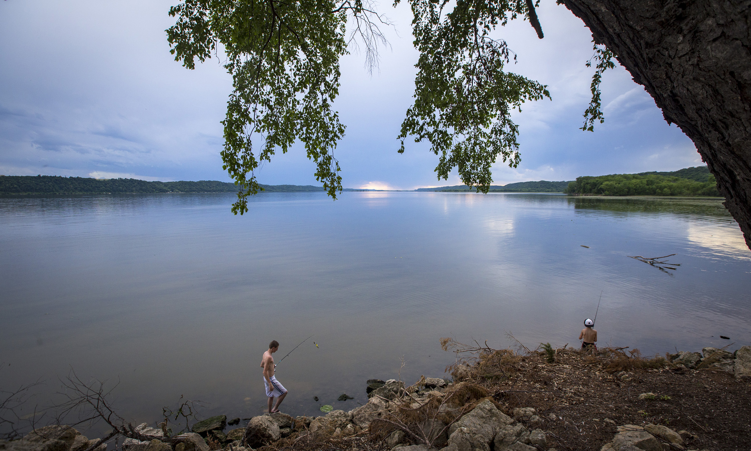Trea Steele, 17, of Gays Mills, Wisconsin walks over toward Tristan Eastlick, 9, of Platteville, Wisconsin while fishing at Grant River Recreation Area in Potosi, Wisconsin, Thursday, June 15, 2017. The boys were camping with family at the campground for the first time and managed to catch a half dozen fish in just about an hour of fishing with worms.