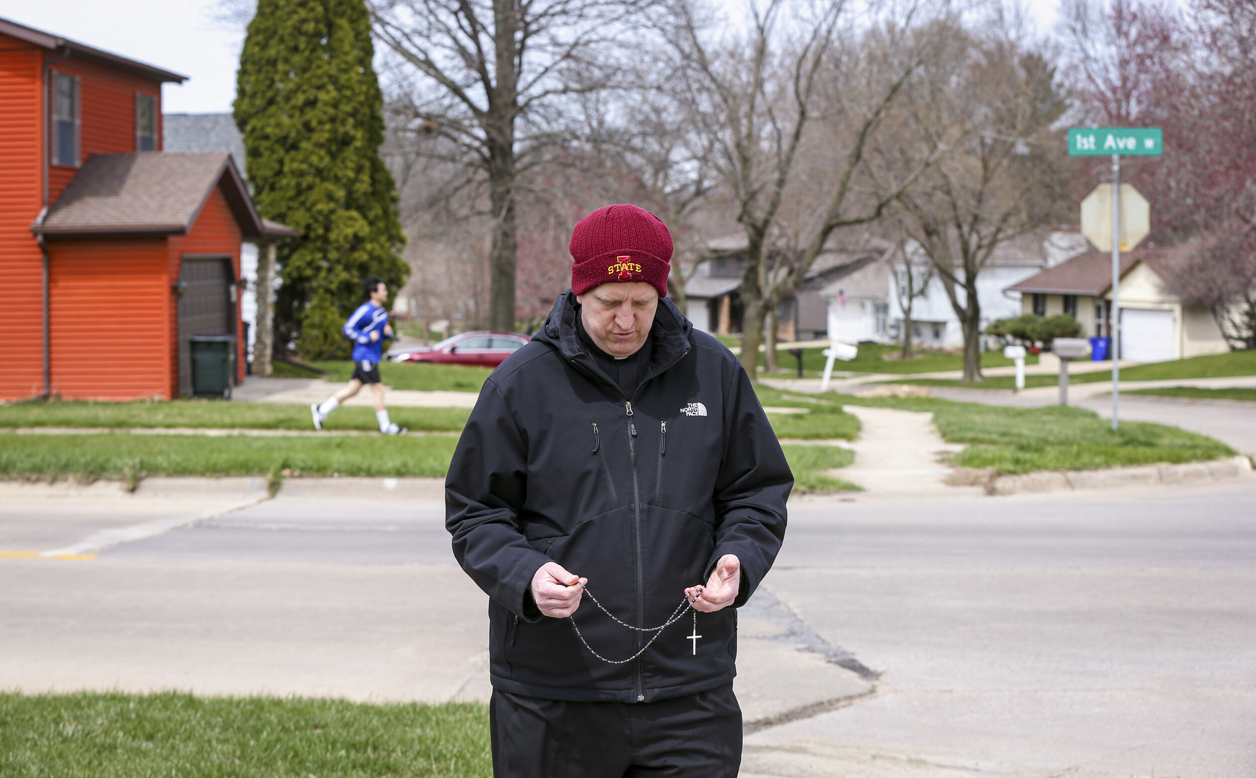  Rev. Mark Murphy, pastor of St. Jude’s Catholic church, says a prayer on the sidewalk nearest the corner of Heritage Specialty Care he believes houses the coronavirus infected residents in Cedar Rapids, Iowa, Thursday. Rev. Murphy began praying outs