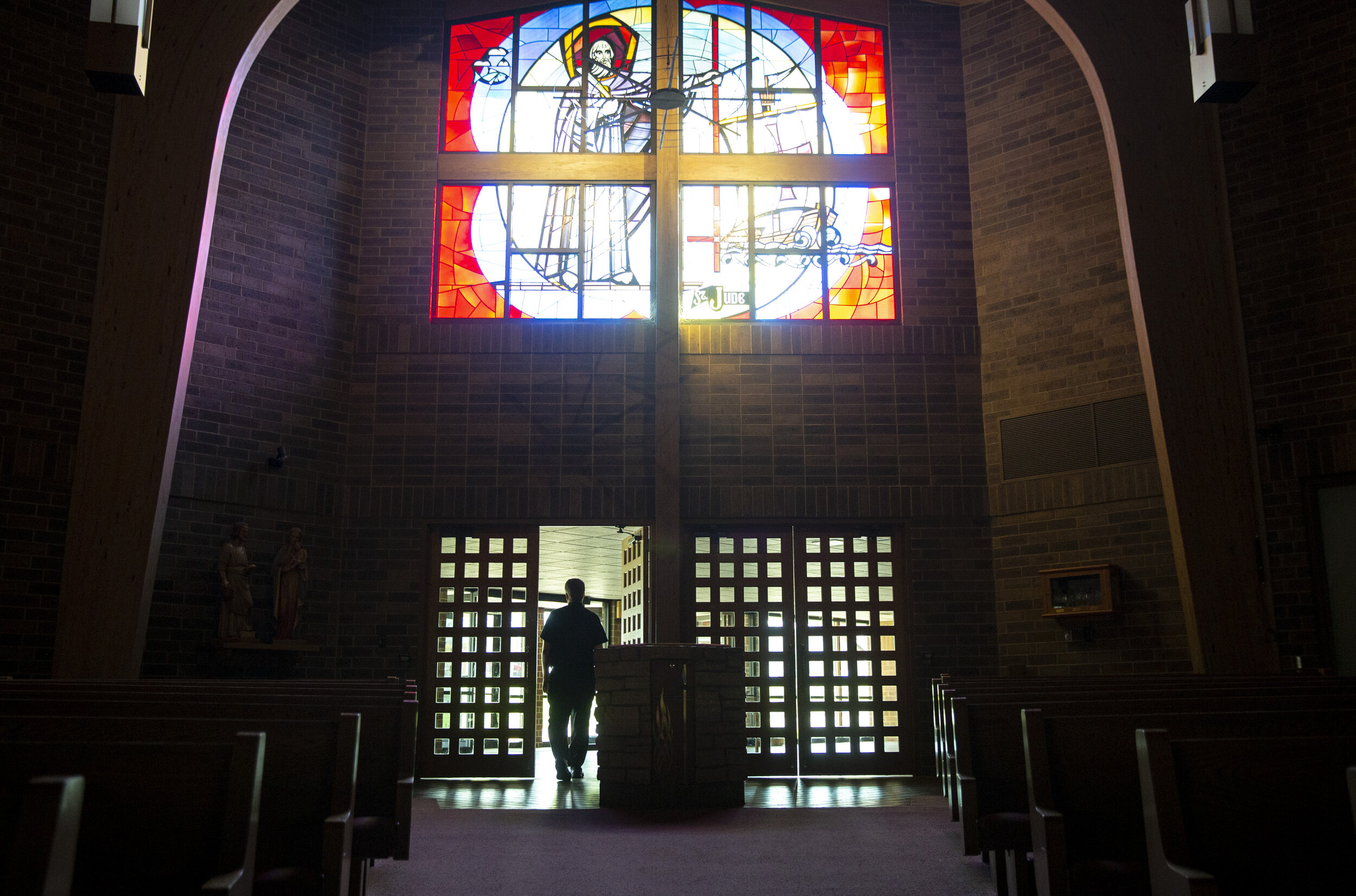  Rev. Mark Murphy walks out of the sanctuary back to his office before recording mass at St. Jude’s Catholic Church on Saturday.  