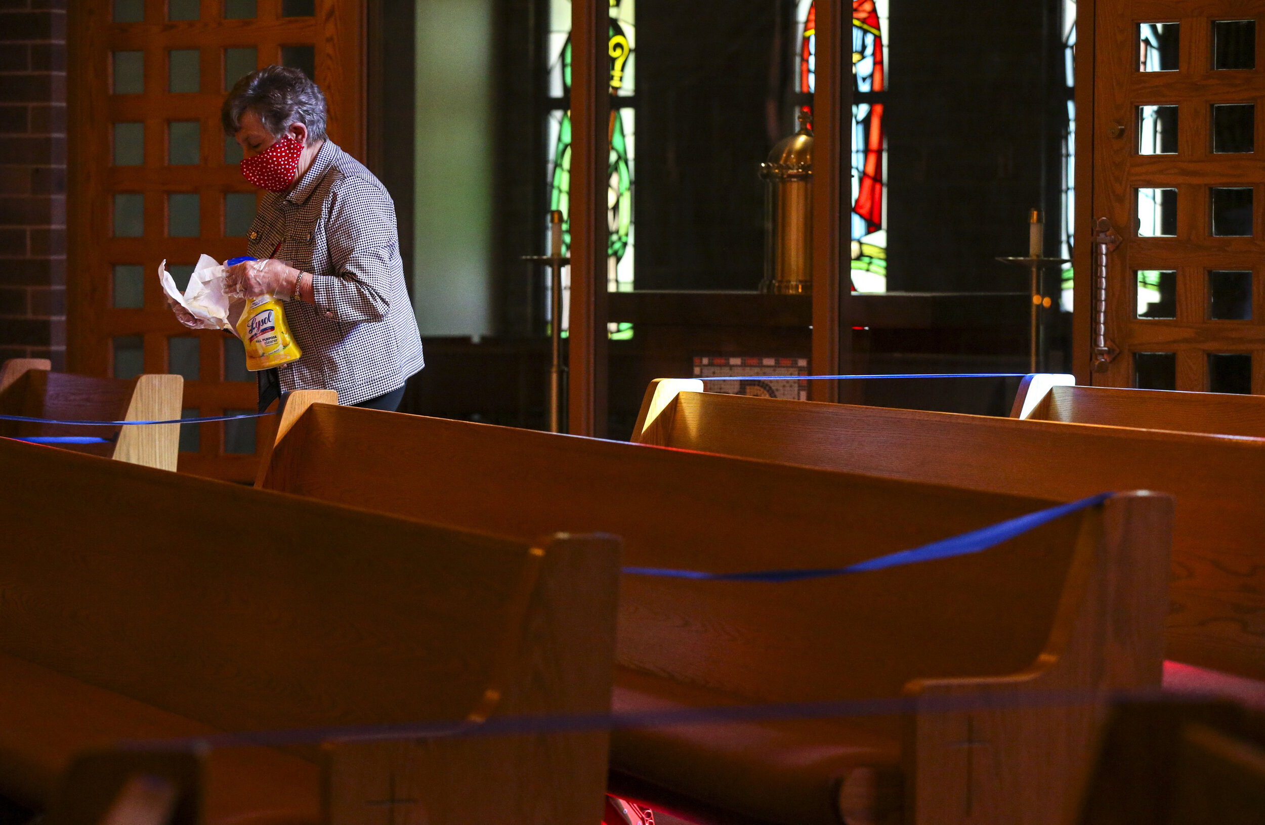 Parishioner Mardean Cook works through a section of pews sanitizing the various surfaces in the church while volunteering after the evening mass at St. Jude’s Catholic Church in Cedar Rapids on Saturday. The church opened up for its first mass since