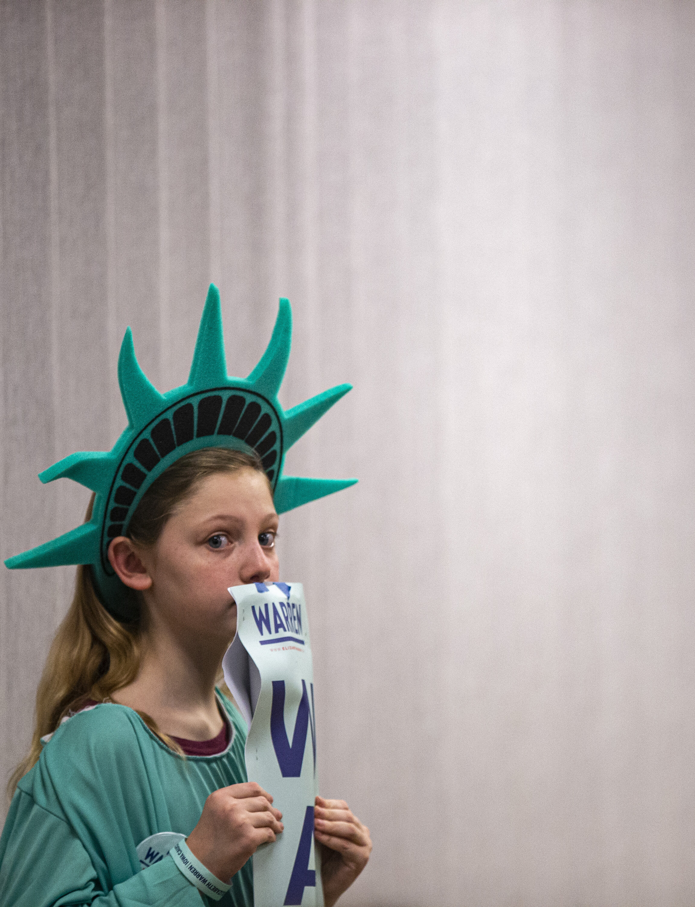  Saoirse Hermann-Wickham, 9, of West Liberty holds a sign in support of Democratic presidential candidate Sen. Elizabeth Warren while dressed as Lady Liberty at the precinct two caucus site at the community center in West Liberty, Iowa, Monday. 