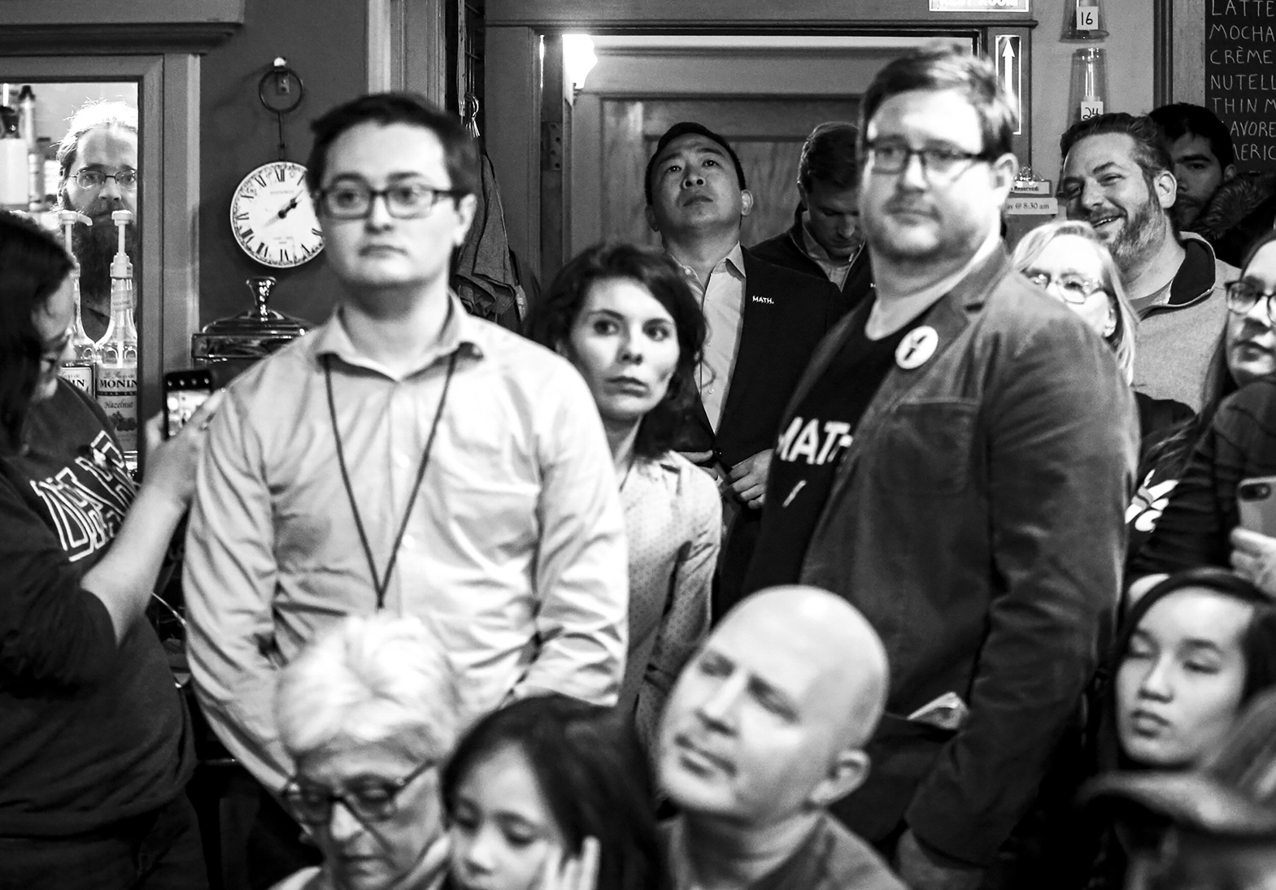  Democratic presidential candidate and entrepreneur Andrew Yang stands behind the crowd as he’s introduced by his wife, Evelyn Yang, during a campaign event at Cafe Dodici in Washington, Iowa, Sunday.  