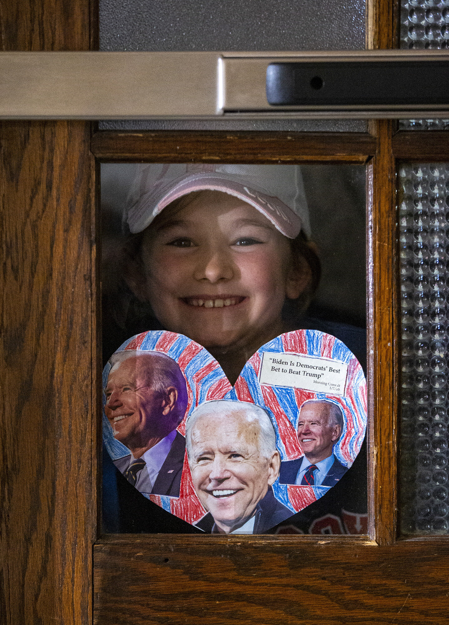  Lila MacInnis-Baumert, 9, of Iowa City holds up a sign she made earlier in the morning at the kitchen table while waiting to be let in the room to see Democratic presidential candidate former Vice President Joe Biden speak during a community event a