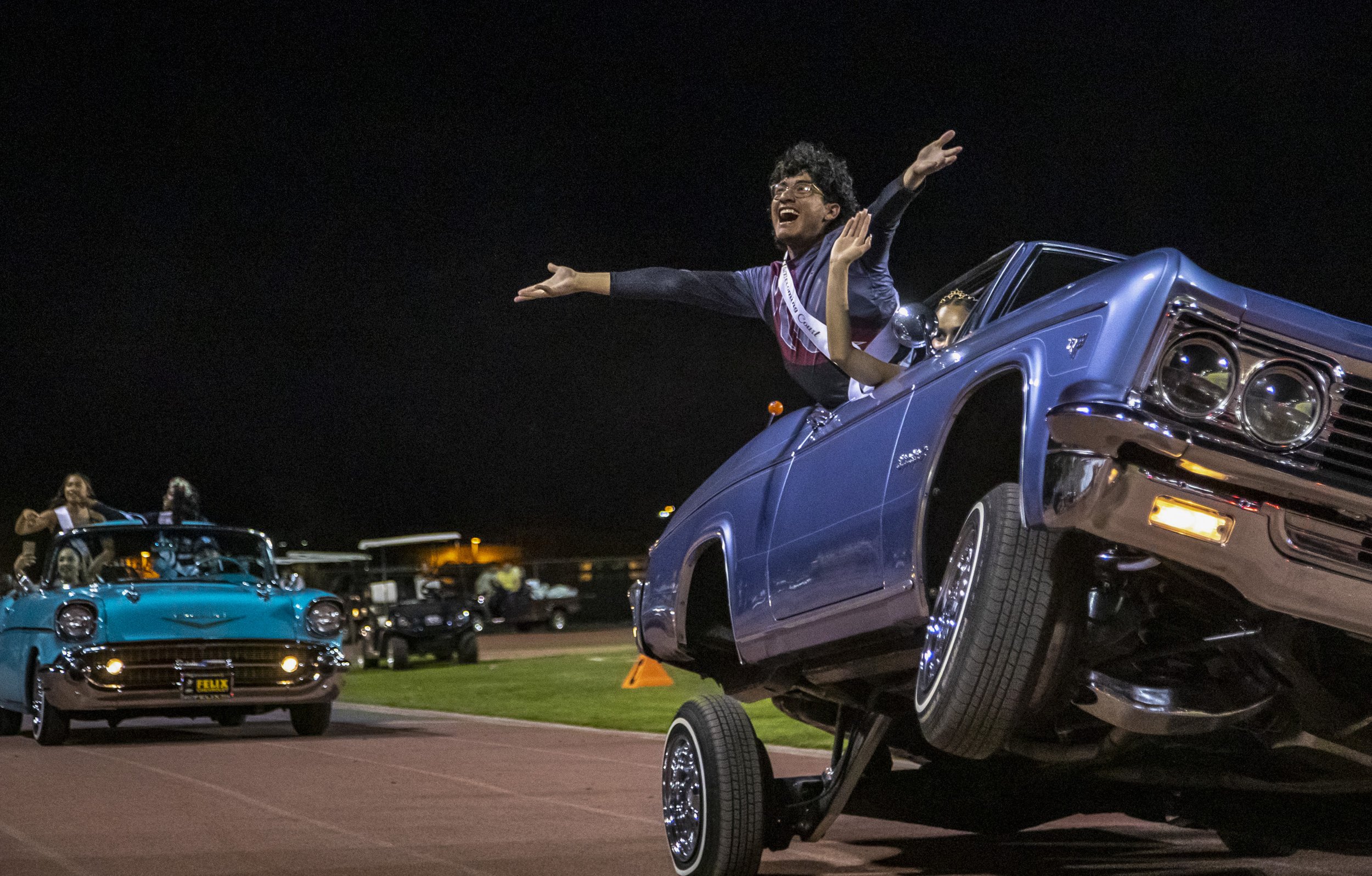  La Quinta homecoming court members Andres Dominguez, 17, and Jaydyn Leon, 17, wave to the crowd as they’re driven out in a parade of low riders during halftime at La Quinta High School in La Quinta, Calif., Friday.  