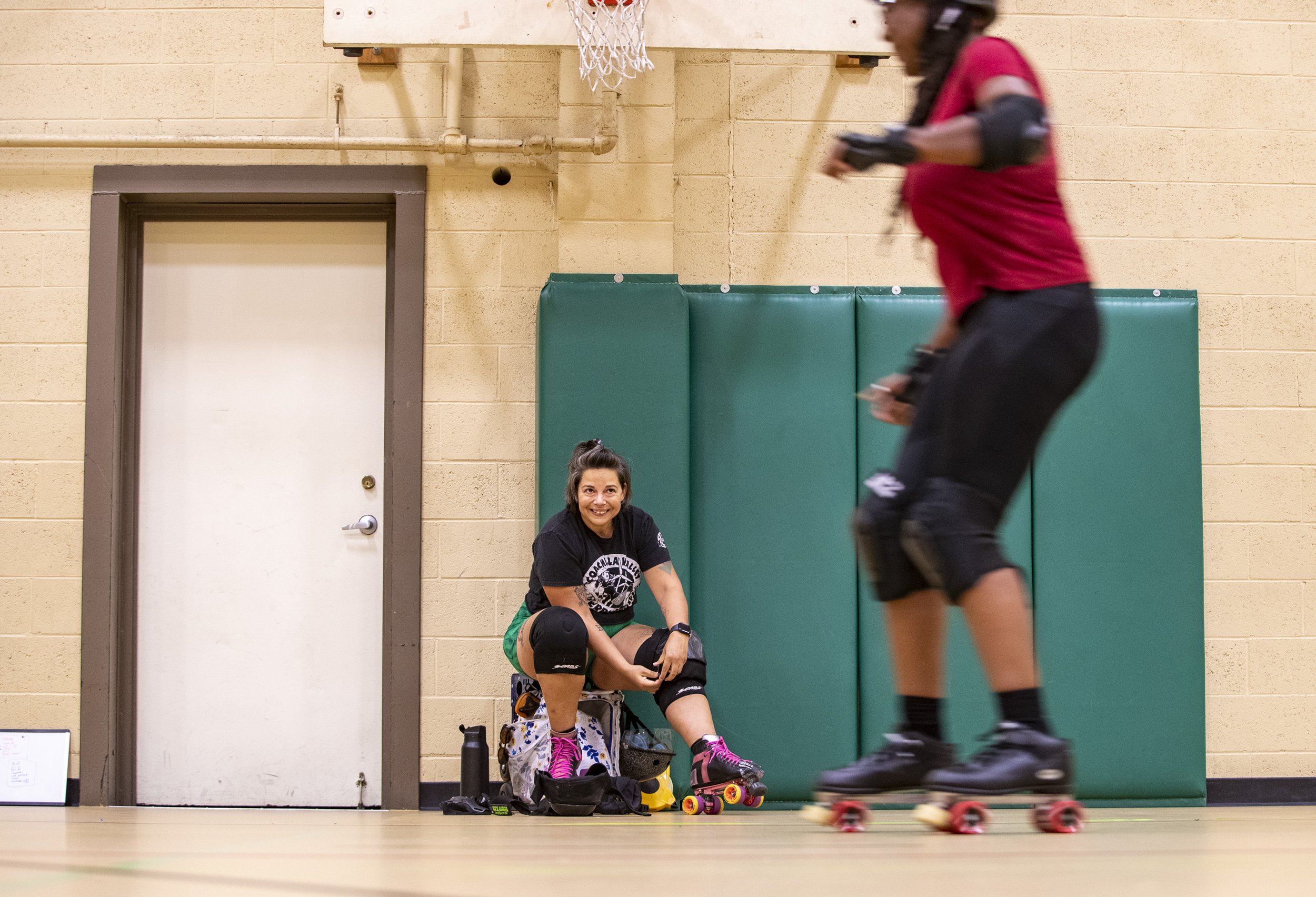  Cheyenne Hall puts on her skates and pads gear to get ready for practice while watching teammate Dawn Jones test out new gear at the James O. Jessie Desert Highland Unity Center in Palm Springs, Calif., Wednesday.  