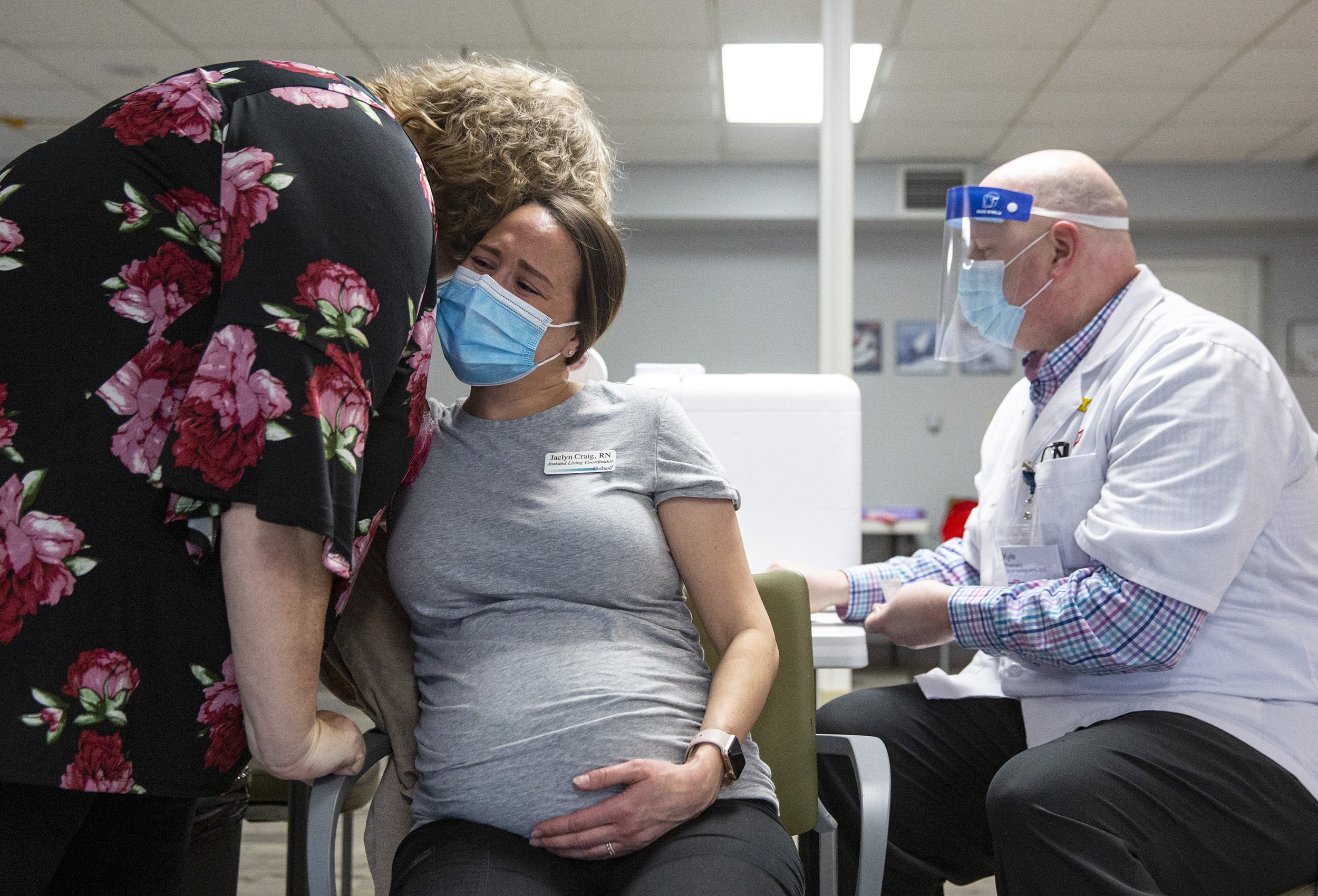  Assisted living coordinator and registered nurse Jaclyn Craig embraces administrator Kim Bergen-Jackson moments after receiving her vaccination from pharmacist Kyle Erkel, her former neighbor, at Oaknoll Retirement Residence in Iowa City on Tuesday.