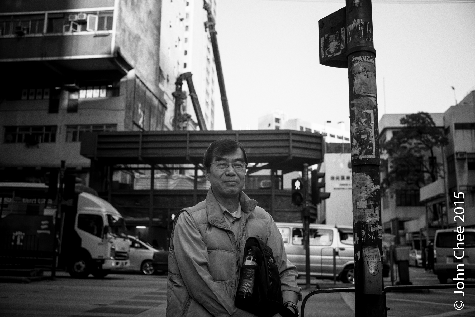 A shop owner standing in front of where his business once was. The lot is now being redeveloped. (Yau Ma Tei, Hong Kong)