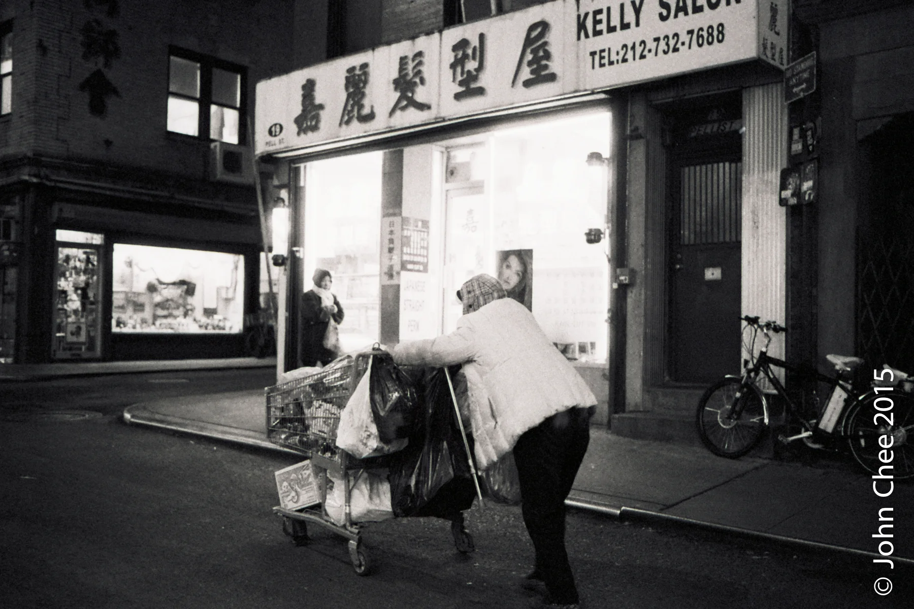 An elderly lady rushing to sell plastic bottles she had collected. Sale of plastic bottle takes place in Chinatown between 6:30 and 7:00 p.m. daily. (Chinatown, Manhattan, New York)