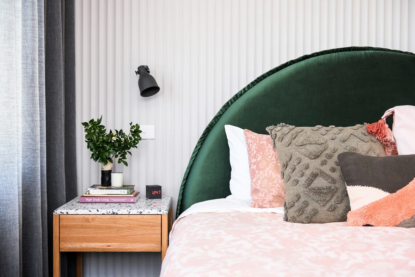 Meet the showstopper: a curvy, forest-green, velvet bedhead that sets the tone for the whole room. Layered bedding, a terrazzo bedside, and simple lighting makes it feel lived-in and inviting. Who knew green could feel this good?

Wall panelling: @su