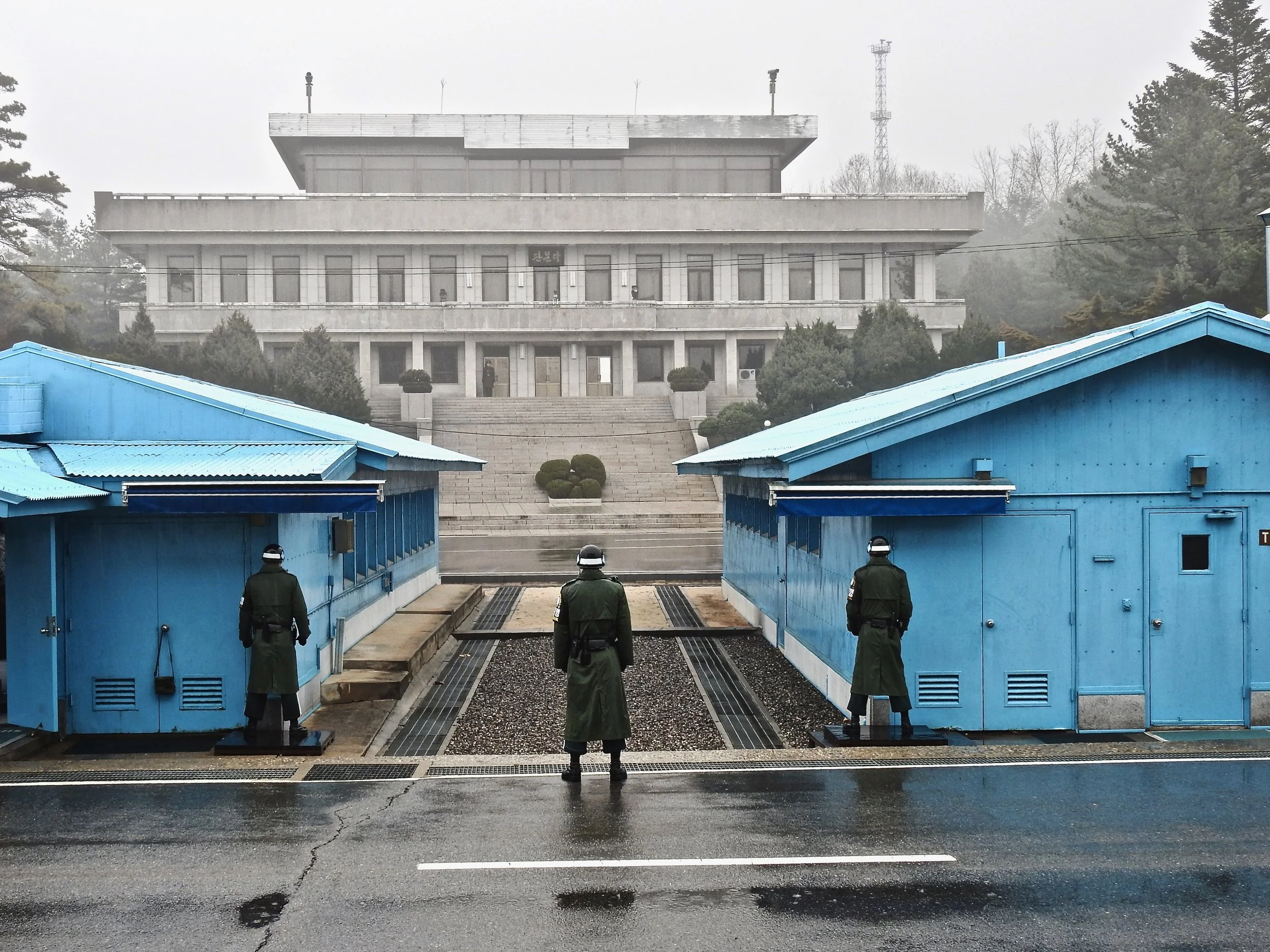 South Korean soldiers at the DMZ looking across the border towards a North Korean soldier on guard. (C) Remko Tanis