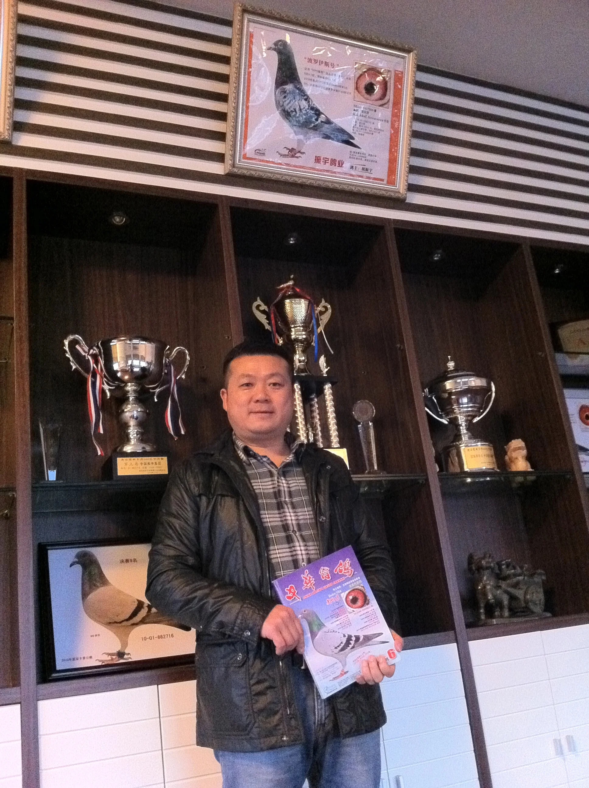 Hu Zhen Yu with pigeon Dolce Vita on the cover of the magazine, which he had just bought for a record amount. Photo: (C) Remko Tanis