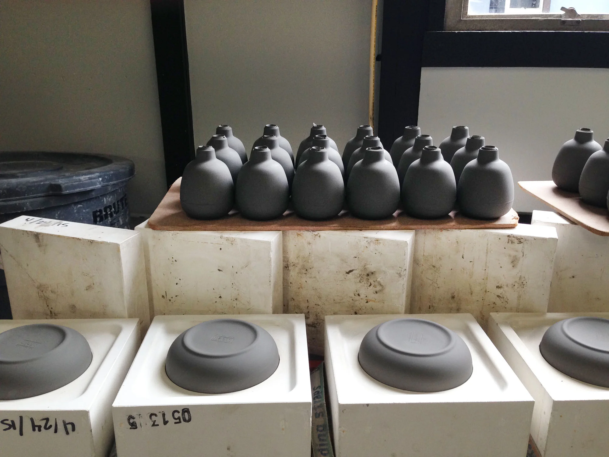 Recently slip cast mini vases and pitchers. The clay is still dark and therefore still relatively wet.
