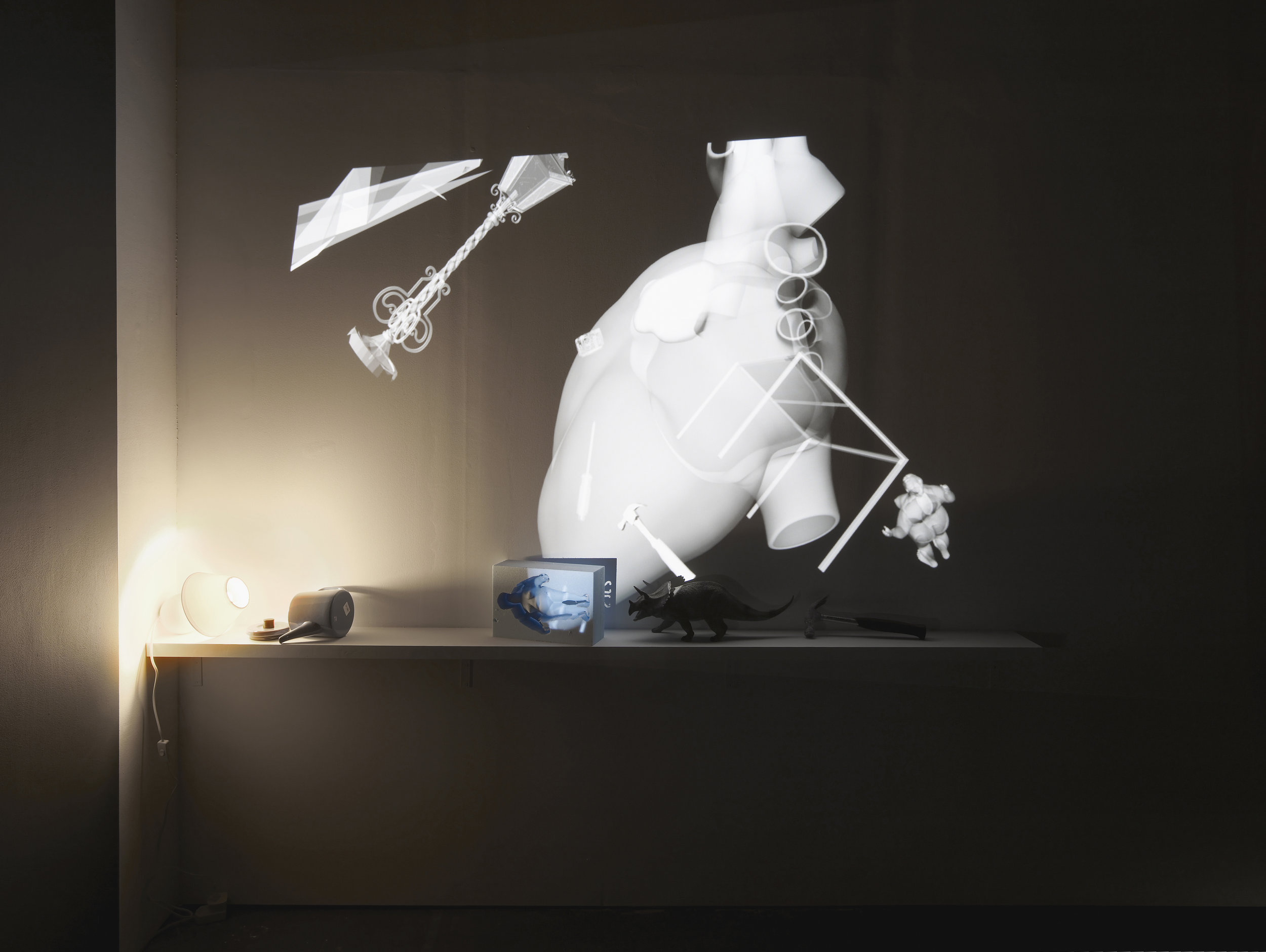     Christina Mackie  Fall Force (Installation)  2012/2017  Stereo vision projection, blu-ray disc, 3D glasses, 3D projector, sofa, teapot, hammer, plastic dinosaur, foam woman and lamp  Dimensions variable 