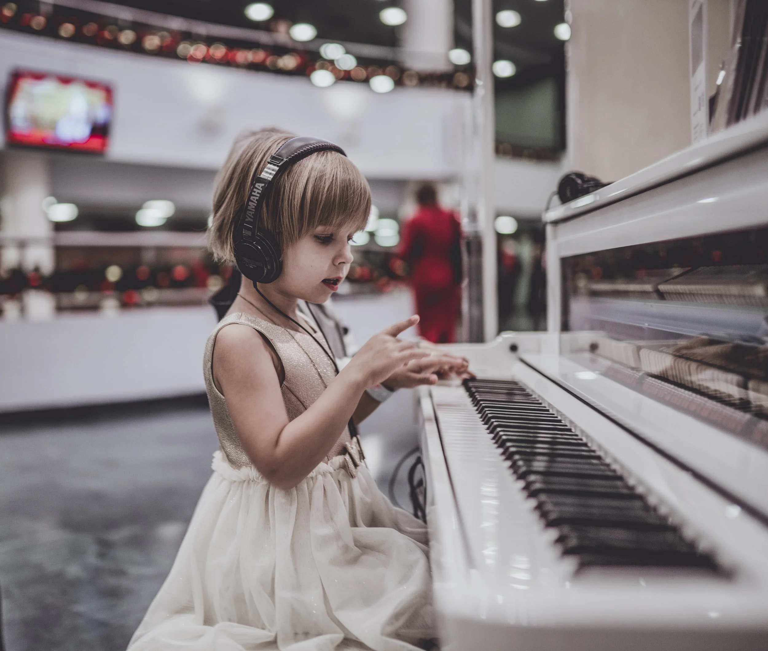 Child playing a piano with headphones. Piano and flute lessons for children and adults in Camarillo, CA.