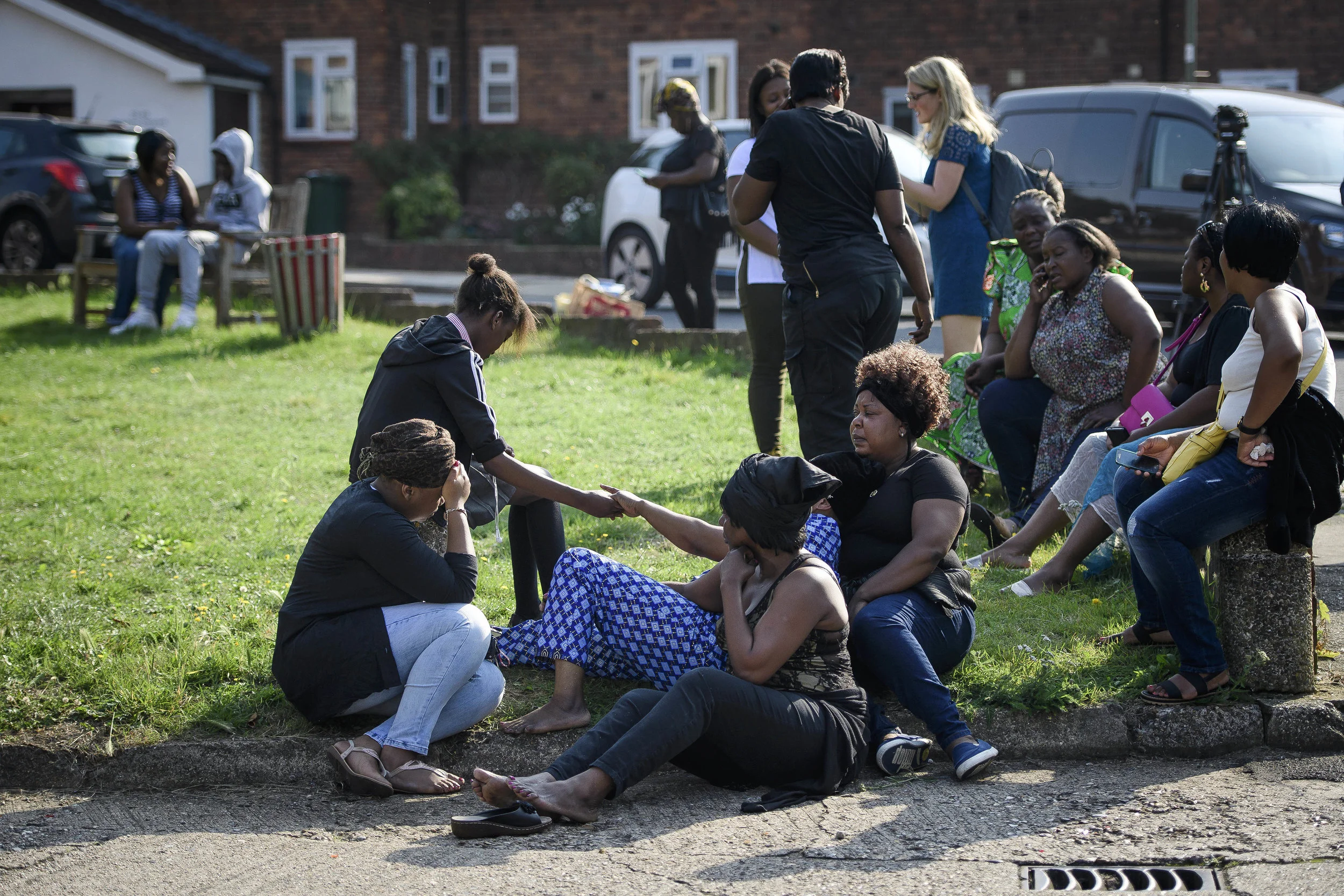  Family of the victim hold hands while grieving at the scene of a shooting in London. 