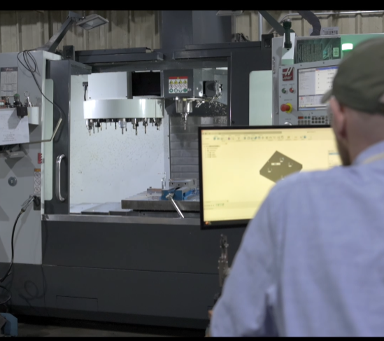 Person operating CNC machine in a workshop