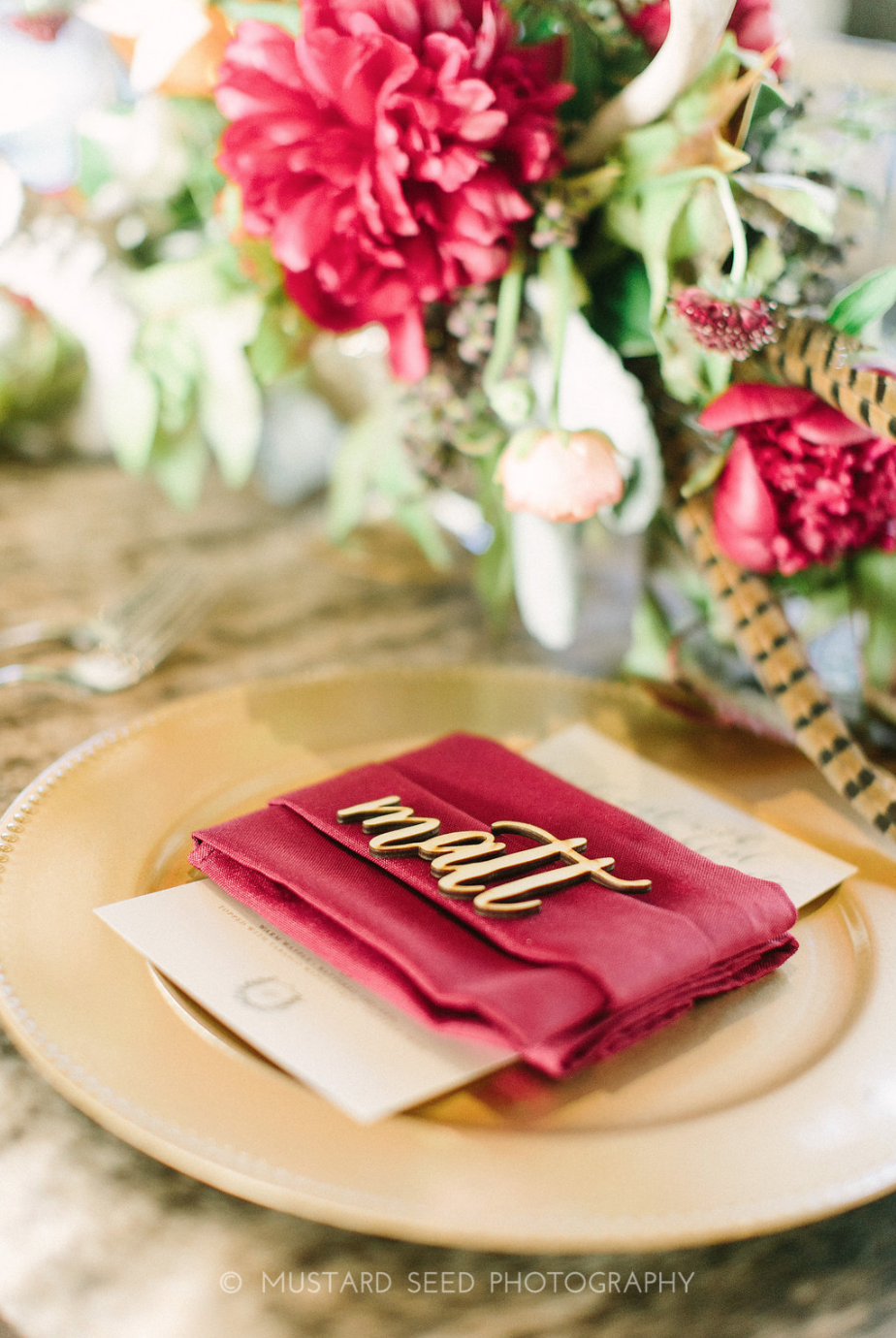 Guest place setting with wooden laser cut name and floral arrangement.