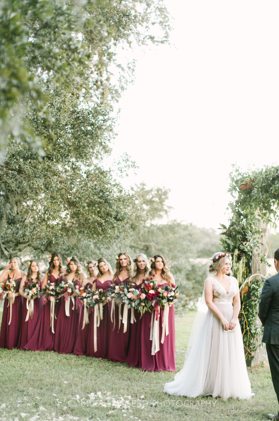 Bride and her bridesmaids during the ceremony. Arch and flowers by Maxit Flower Design in Houston, TX.