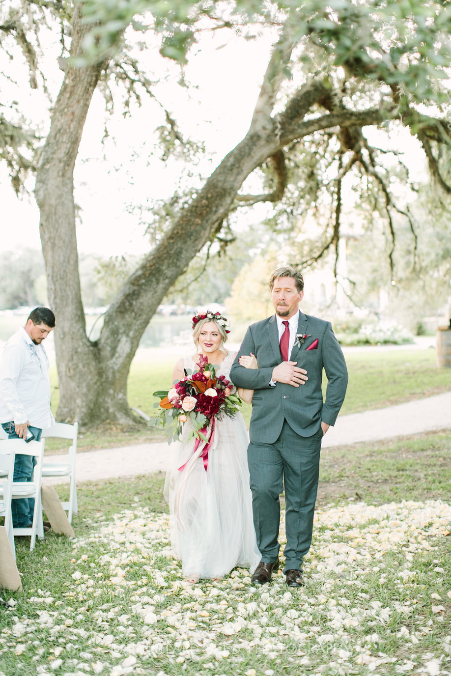 A father walking his daughter down the aisle. Flower crown and bouquet by Maxit Flower Design in Houston, TX.
