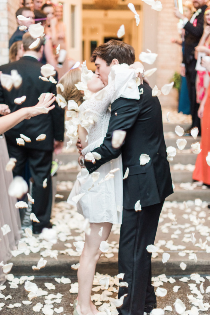 wedding-bride-groom-reception-exit-photography-dana-fernadez-river-oaks-country-club-kiss-rose-petals-floral-greenery-by-maxit-flower-design-houston-texas