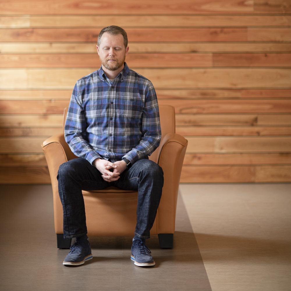 Chad McGehee meditating  while sitting in a chair