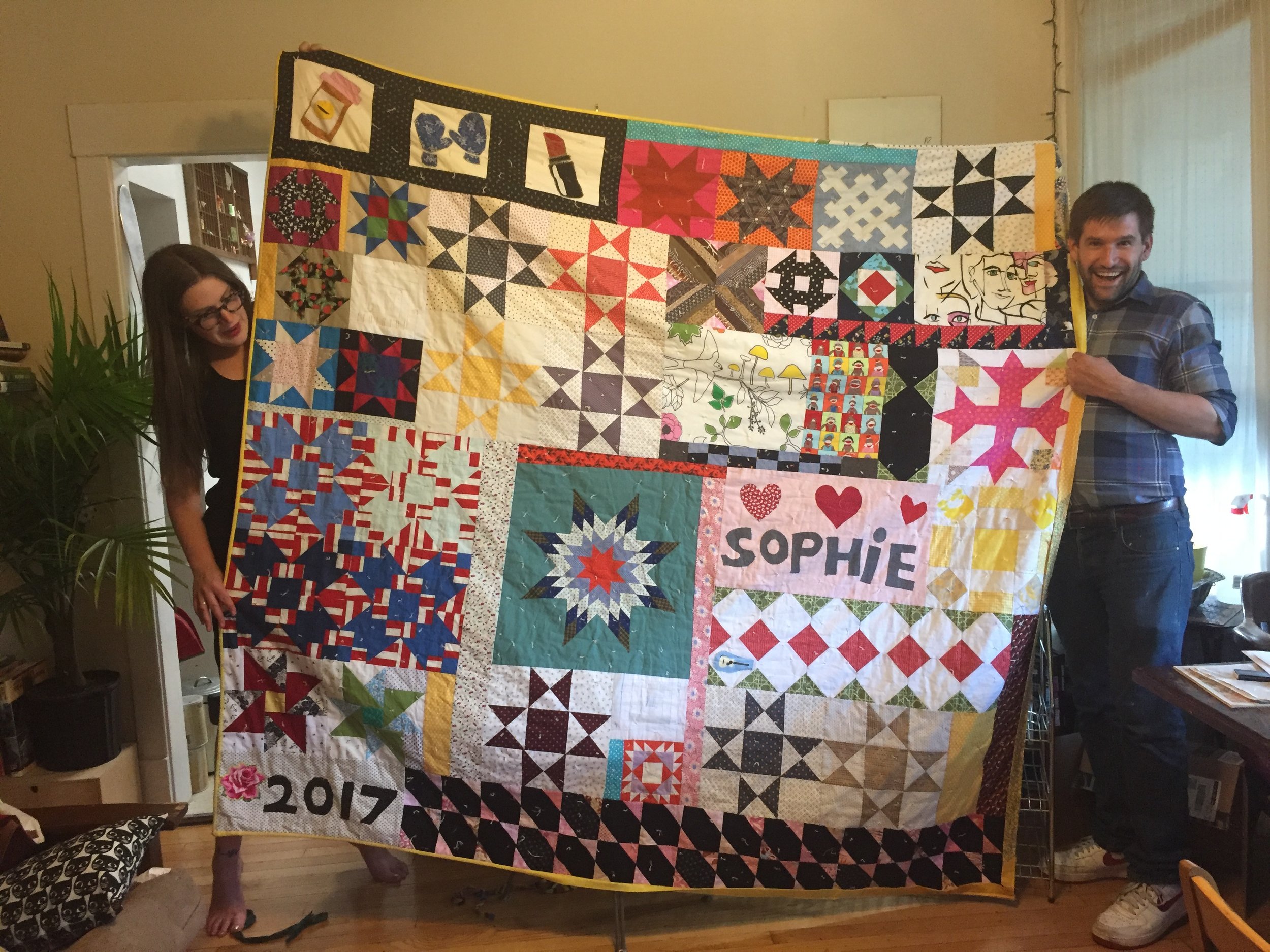 Sophie and Luke hold up the QUILT.