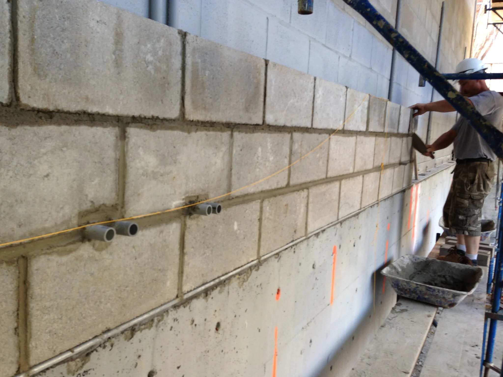 A steel supporting angle was installed atop the neighboring foundation wall to increase the depth of our setting bed. Concrete block was installed at the portions of the party wall that will soon be below finish grade. 