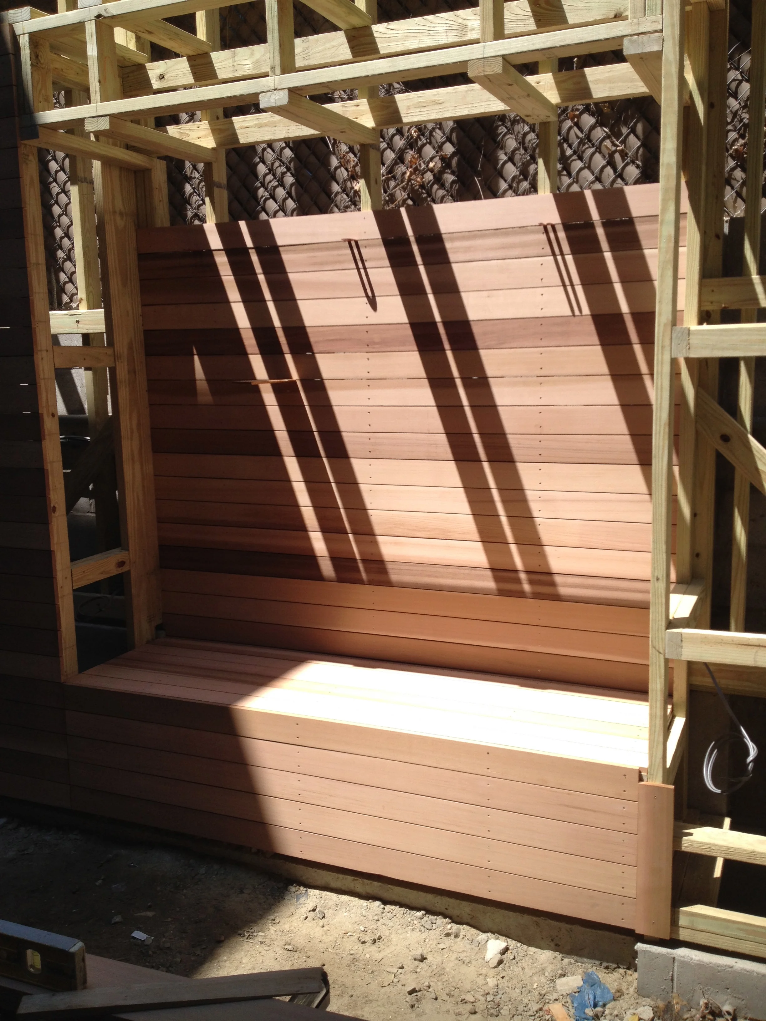 A bench was constructed between the two end closets, integrating seating into the space without encroaching on the limited garden footprint. 