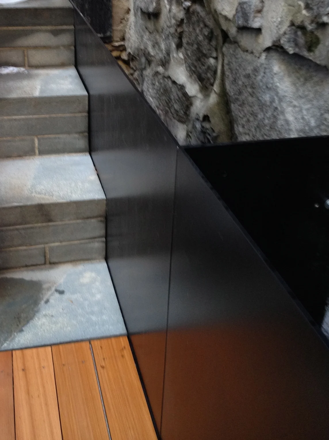 The planters were produced in a 'U' Shape to accommodate the movement in the granite wall. A stainless steel piano hinge was used to make the bench top operable without interference from the planters behind. 
