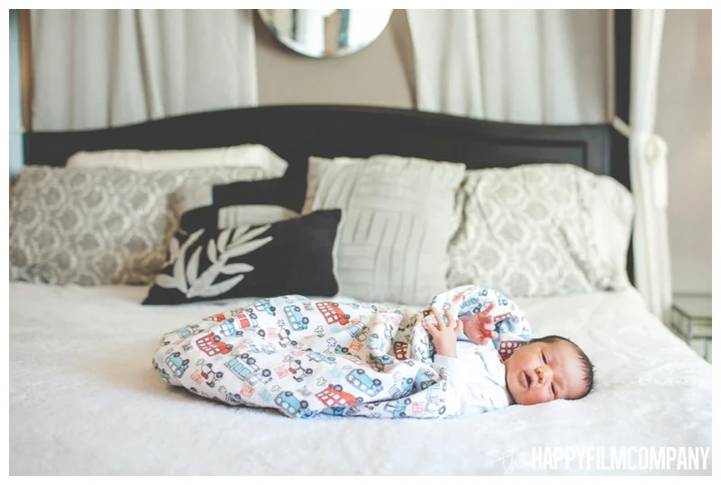 newborn baby on bed - Natural Seattle Newborn Photography - the Happy Film Company