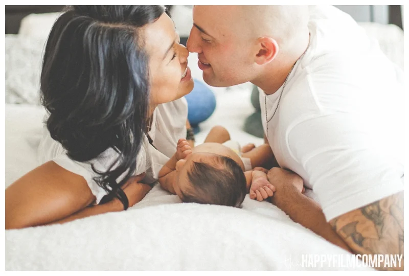 mom and dad kissing over baby portraits - Natural Seattle Newborn Photography - the Happy Film Company