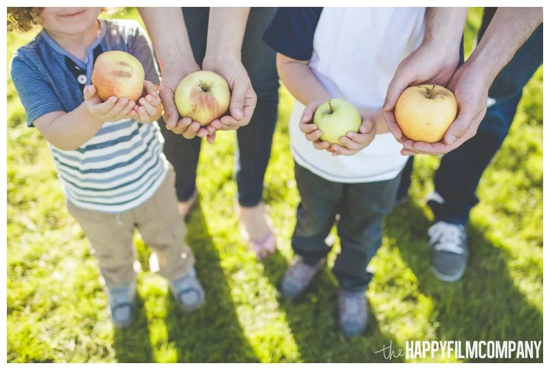 family holding apples in their hands - Seattle Family Apple Picking Photo Shoot - the Happy Film Company