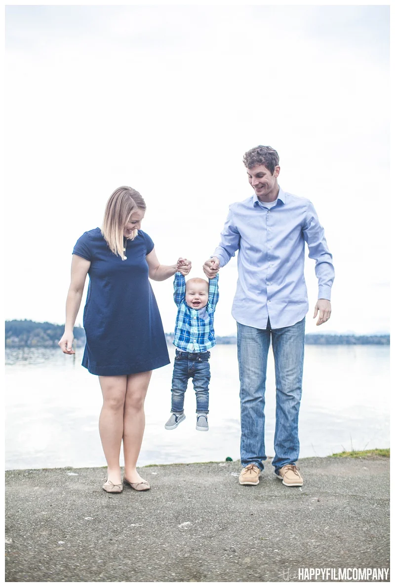 mom and dad holding little boy in air at matthews beach - the Happy Film Company - Seattle PEPS Group Photo Shoot