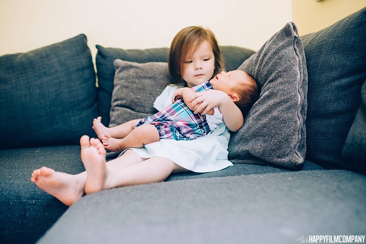 Little girl and newborn baby brother sitting in the couch - the Happy Film Company - Seattle Family Photos
