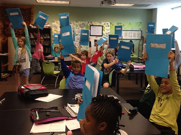 Edmund Burke's 6th grade holds up their futures up high!
